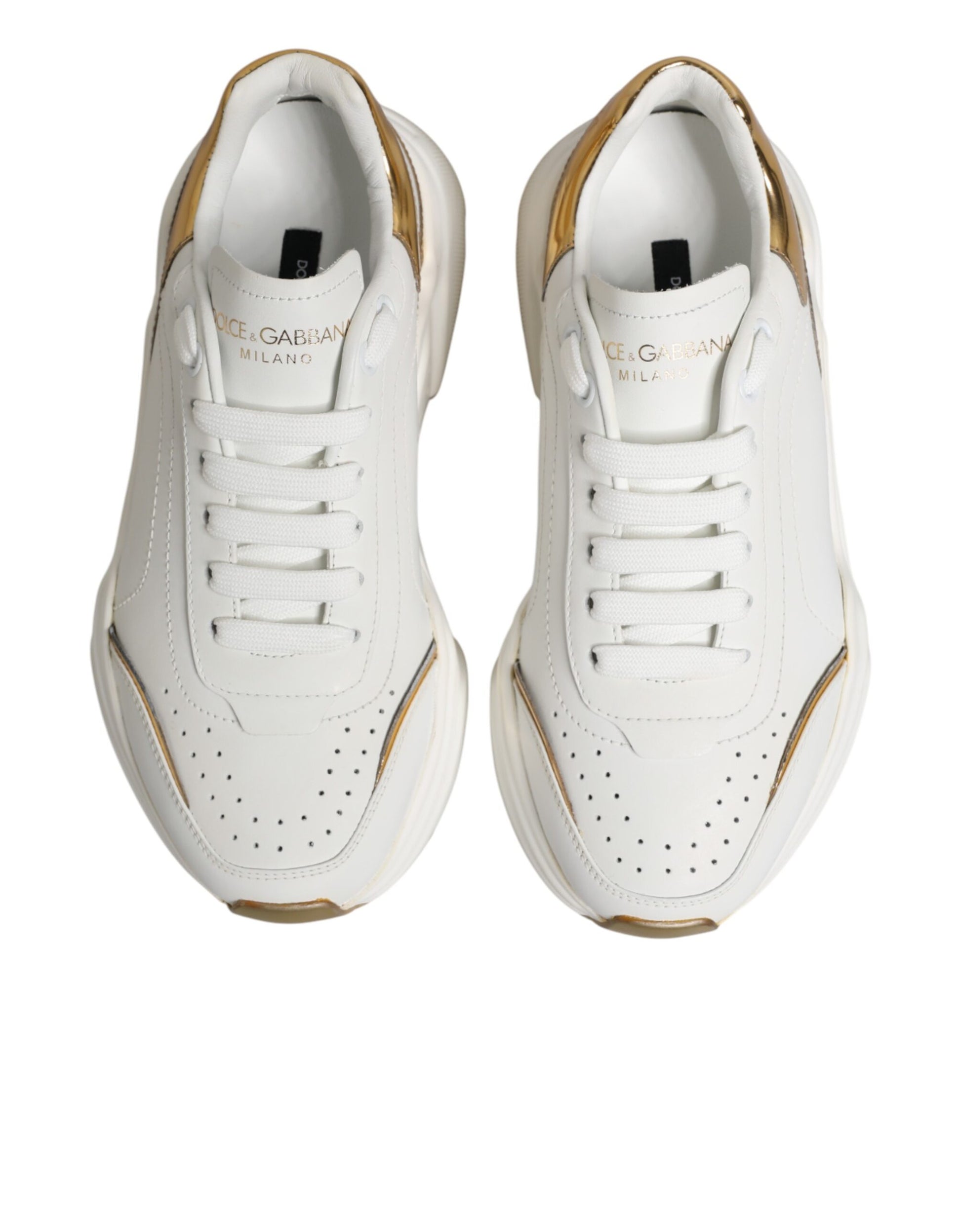Pair of white gold sneakers with black laces and logo on side