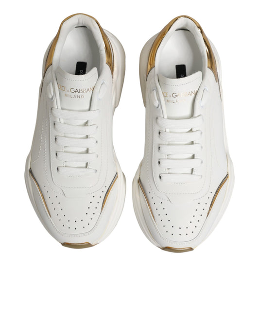 Pair of white gold sneakers with black laces and logo on side