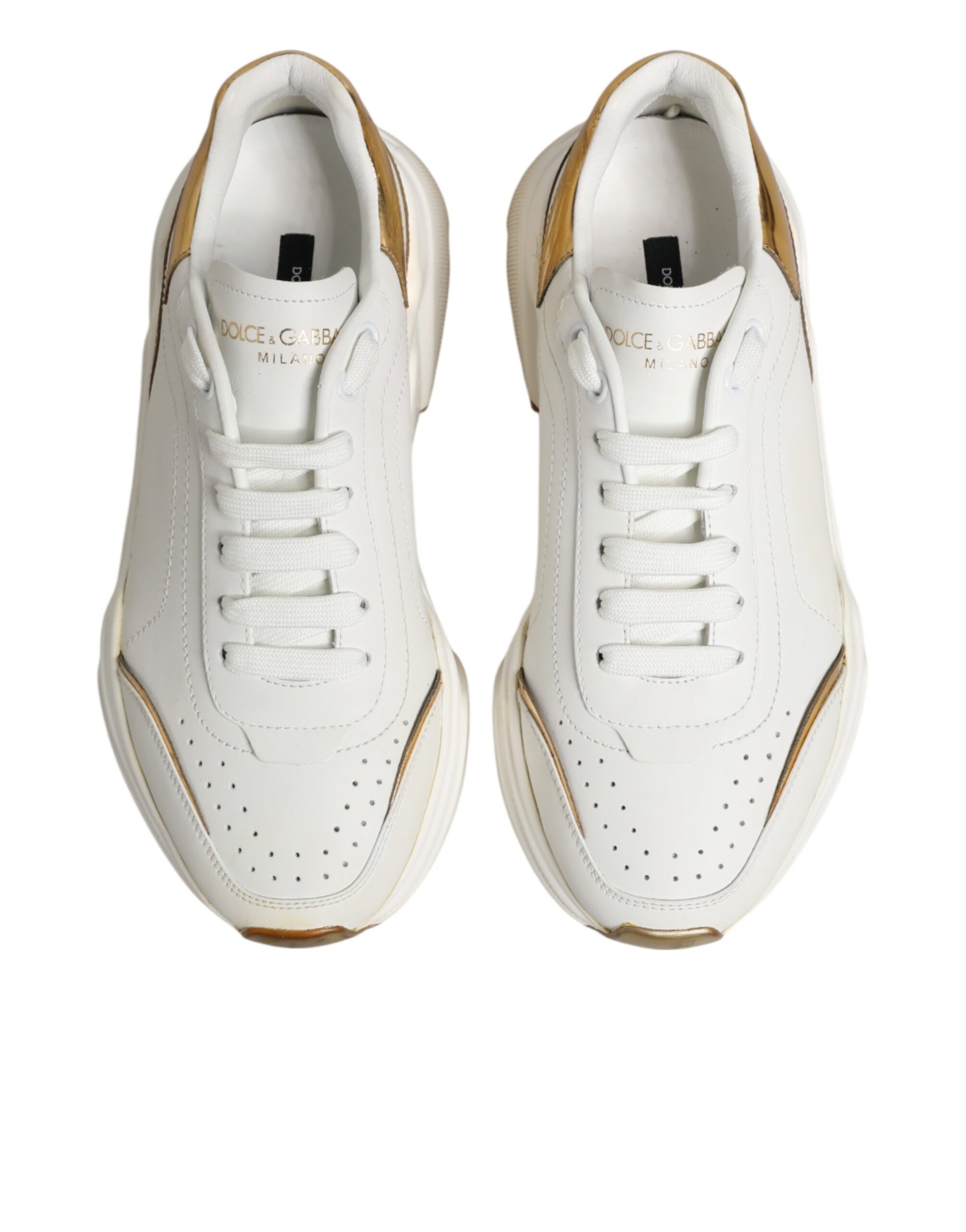 Pair of white gold sneakers with black laces and logo on side