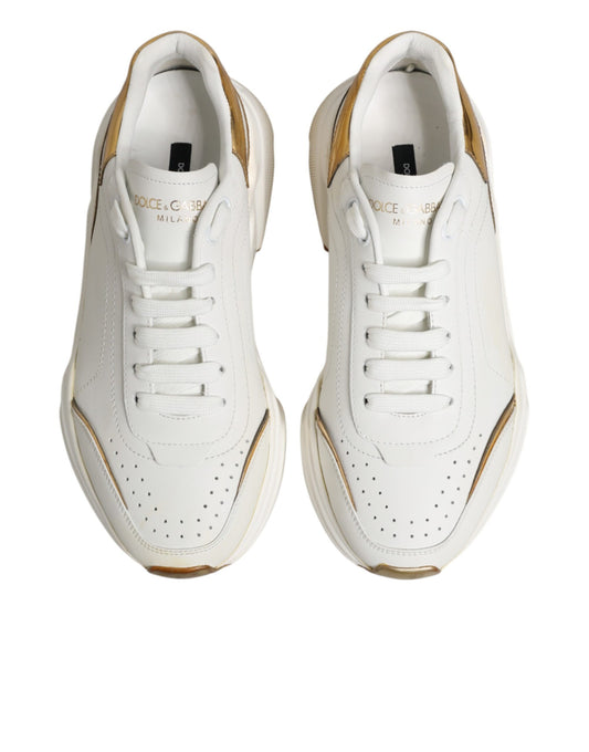 Pair of white gold sneakers with black laces and logo on side