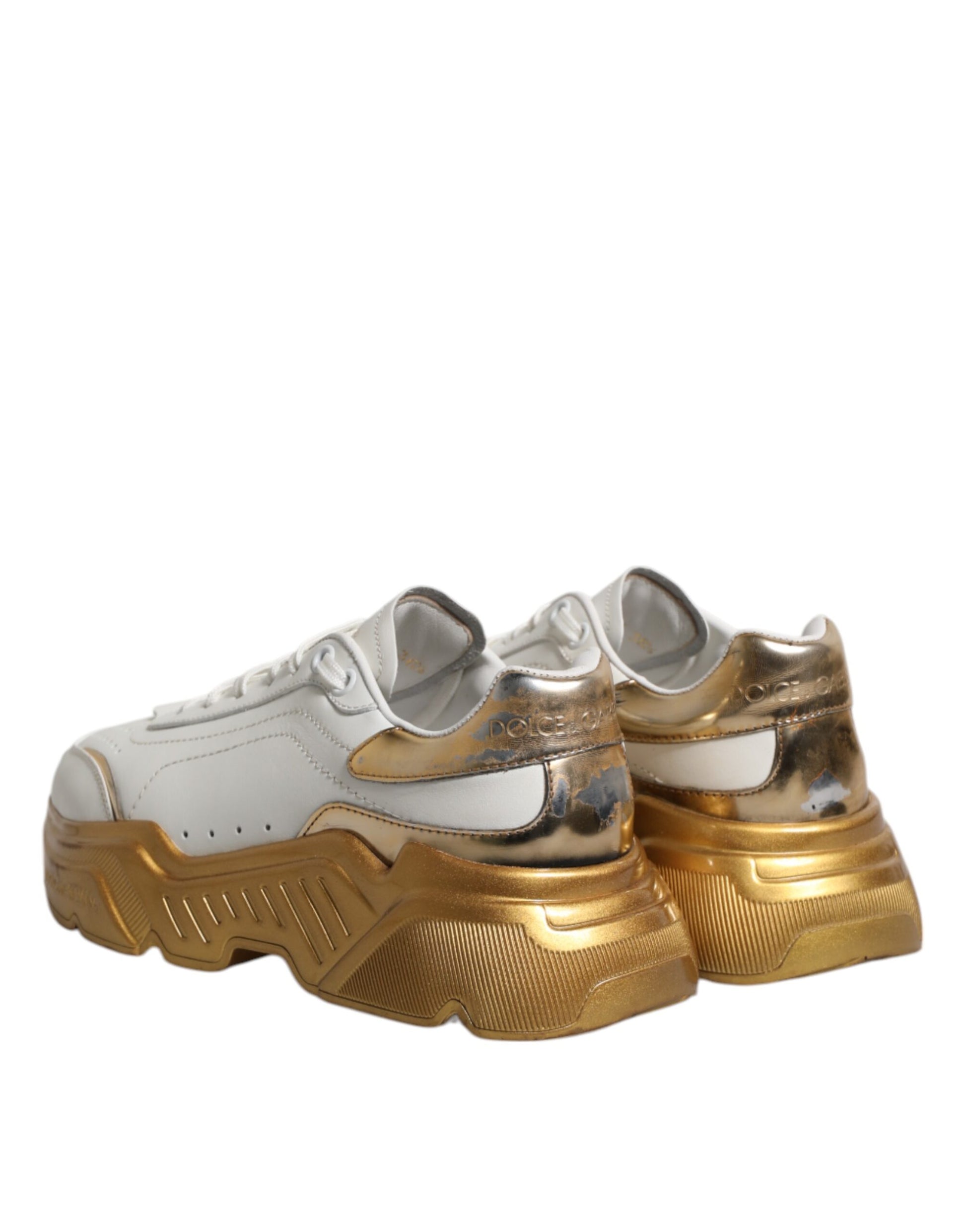 Pair of white gold sneakers with laces, featuring a low top design and a glossy finish
