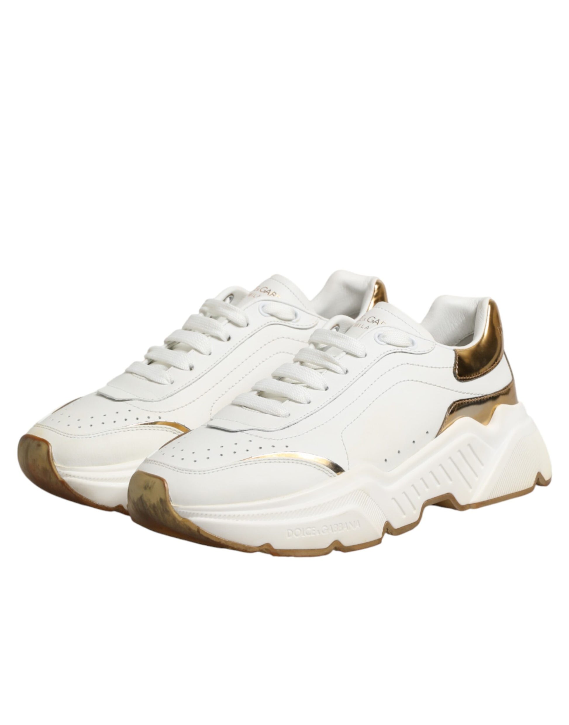 White gold sneakers with white laces, black soles and a logo on the side