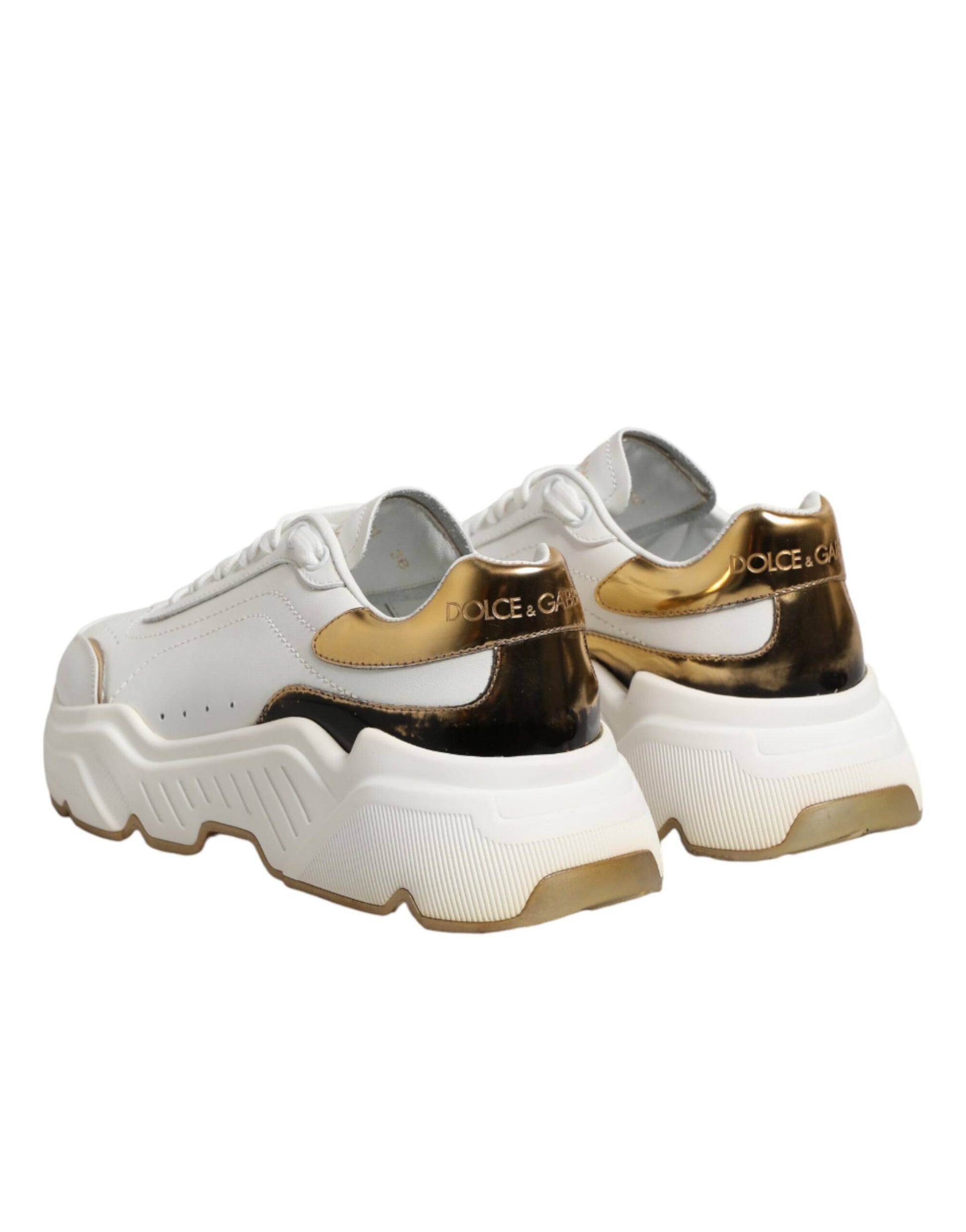 Pair of white gold sneakers with black laces and logo on side