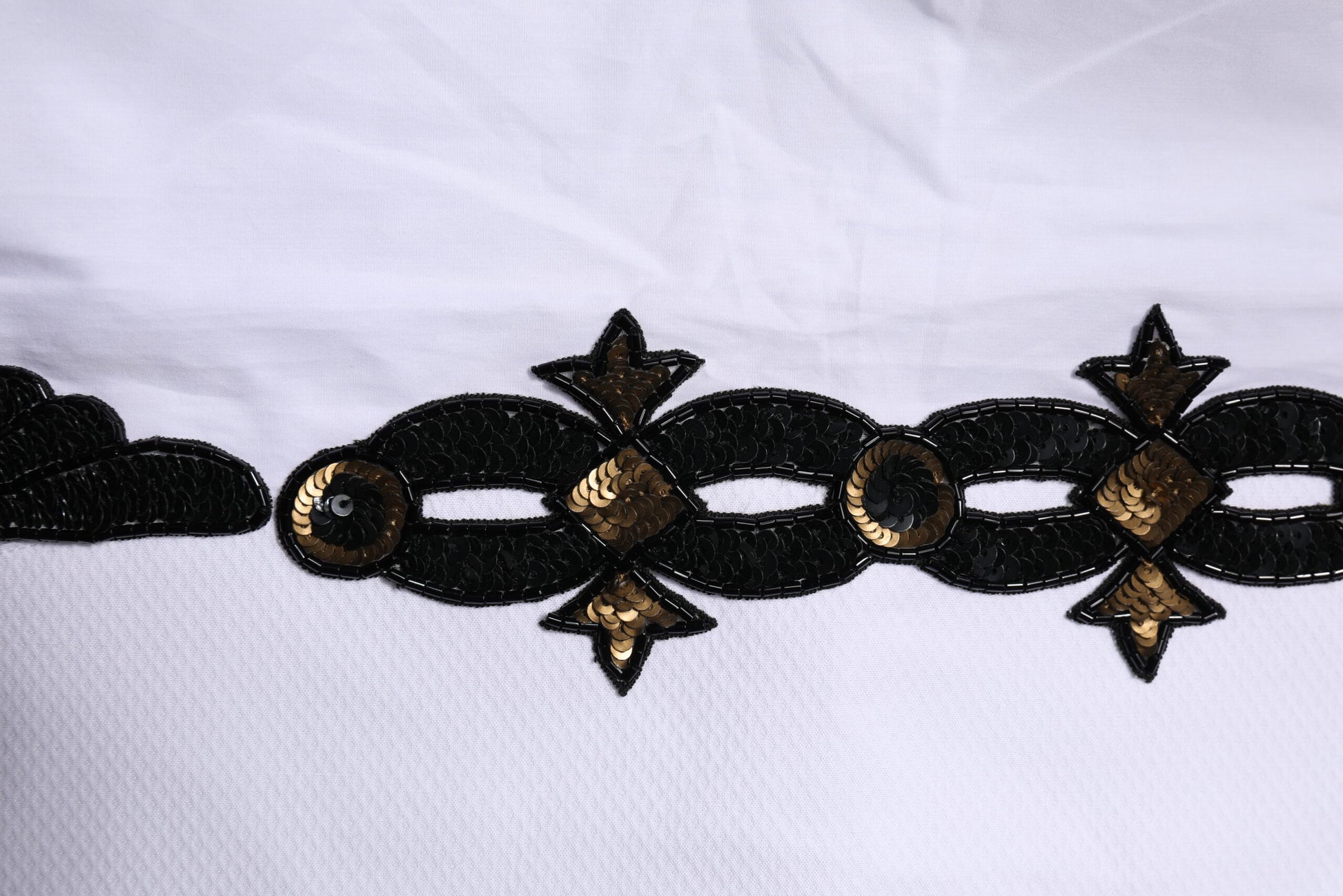 Gold embellishments on white shirt