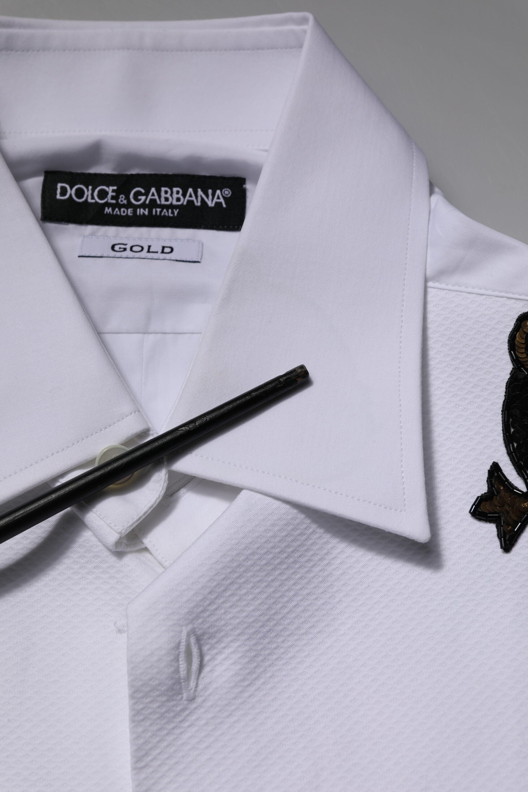 A white dress shirt with gold embellishments from the brand Dolce & Gabbana