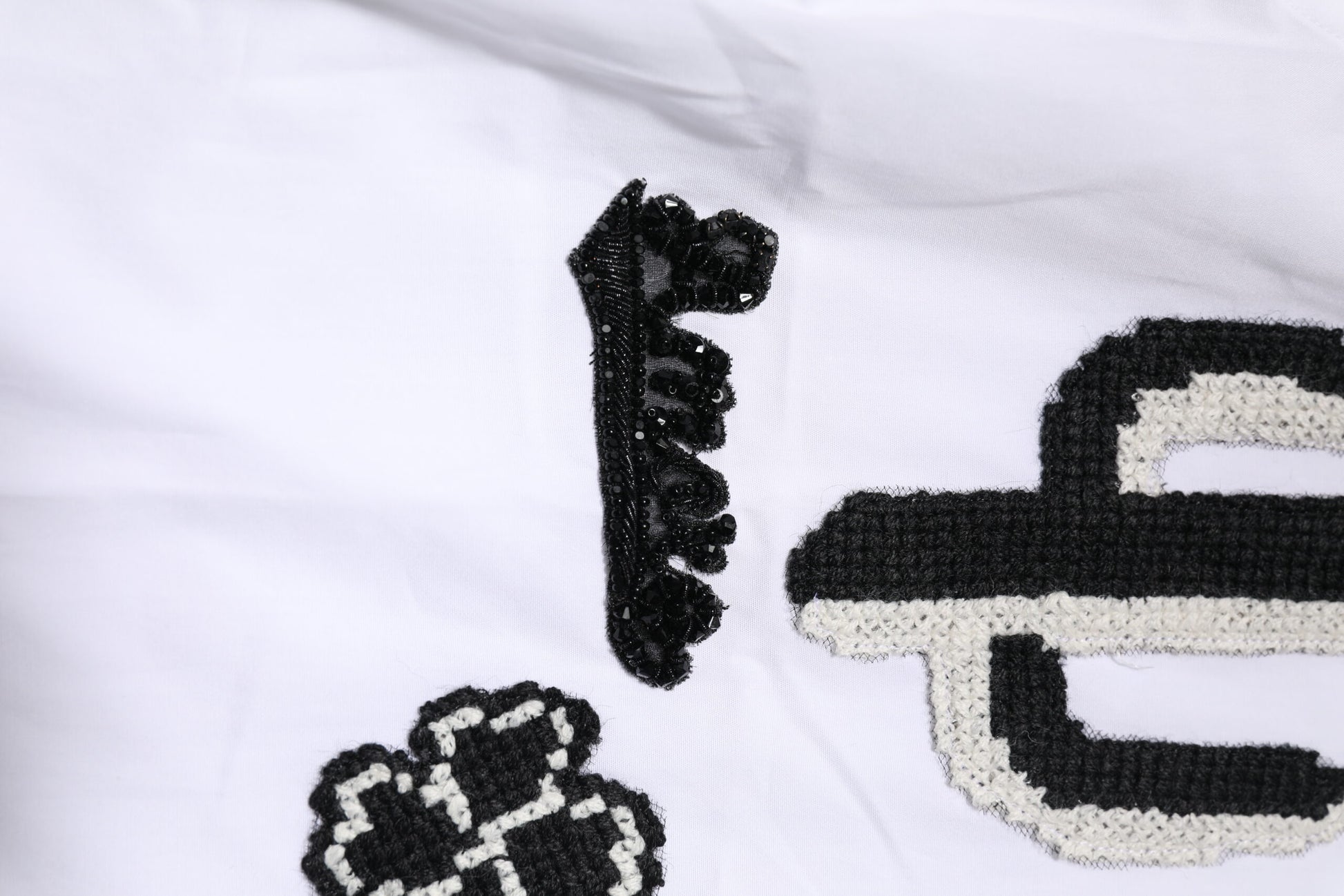 A white dress shirt with gold embroidery and a detailed design on the front