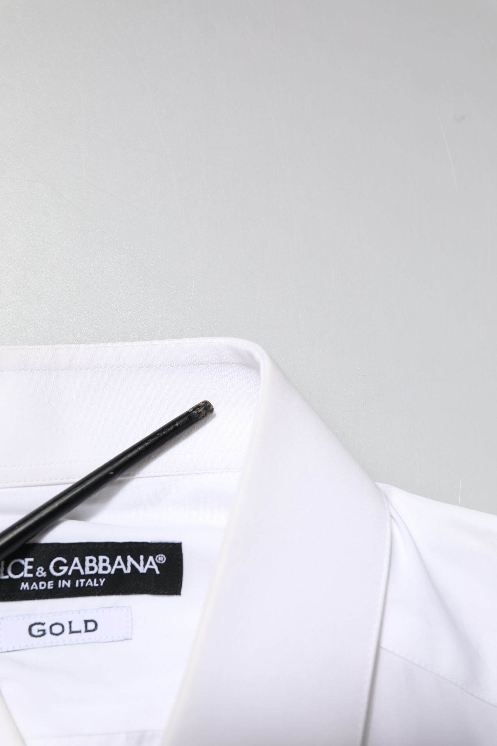 A white dress shirt with gold embroidery detailing, from the brand Dolce & Gabbana