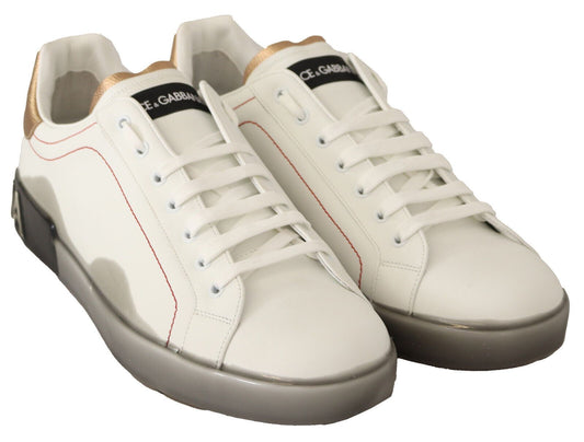 Pair of white sneakers with red accents and gold laces