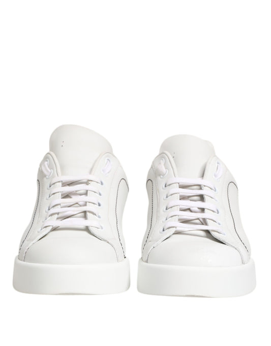 Pair of white gold leather low top sneakers with laces and a logo on the side