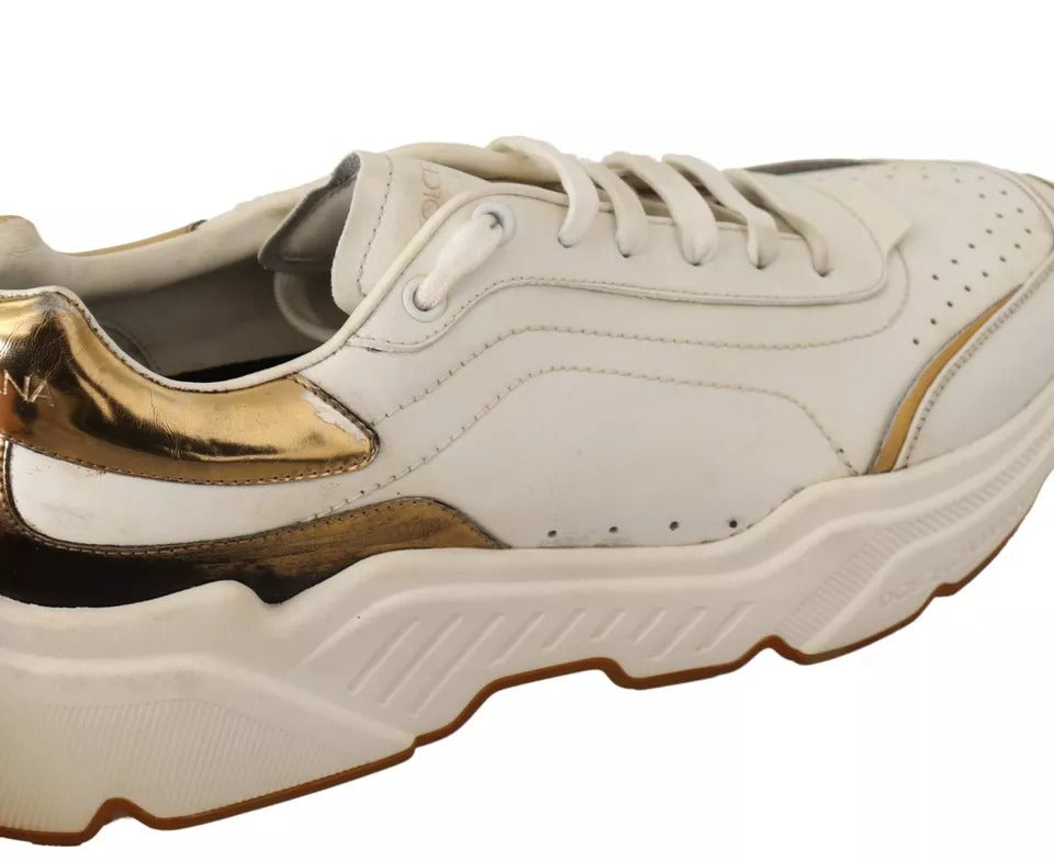 A pair of white gold leather sneakers with a sporty design, featuring the brand name "Dolce & Gabbana" on the side