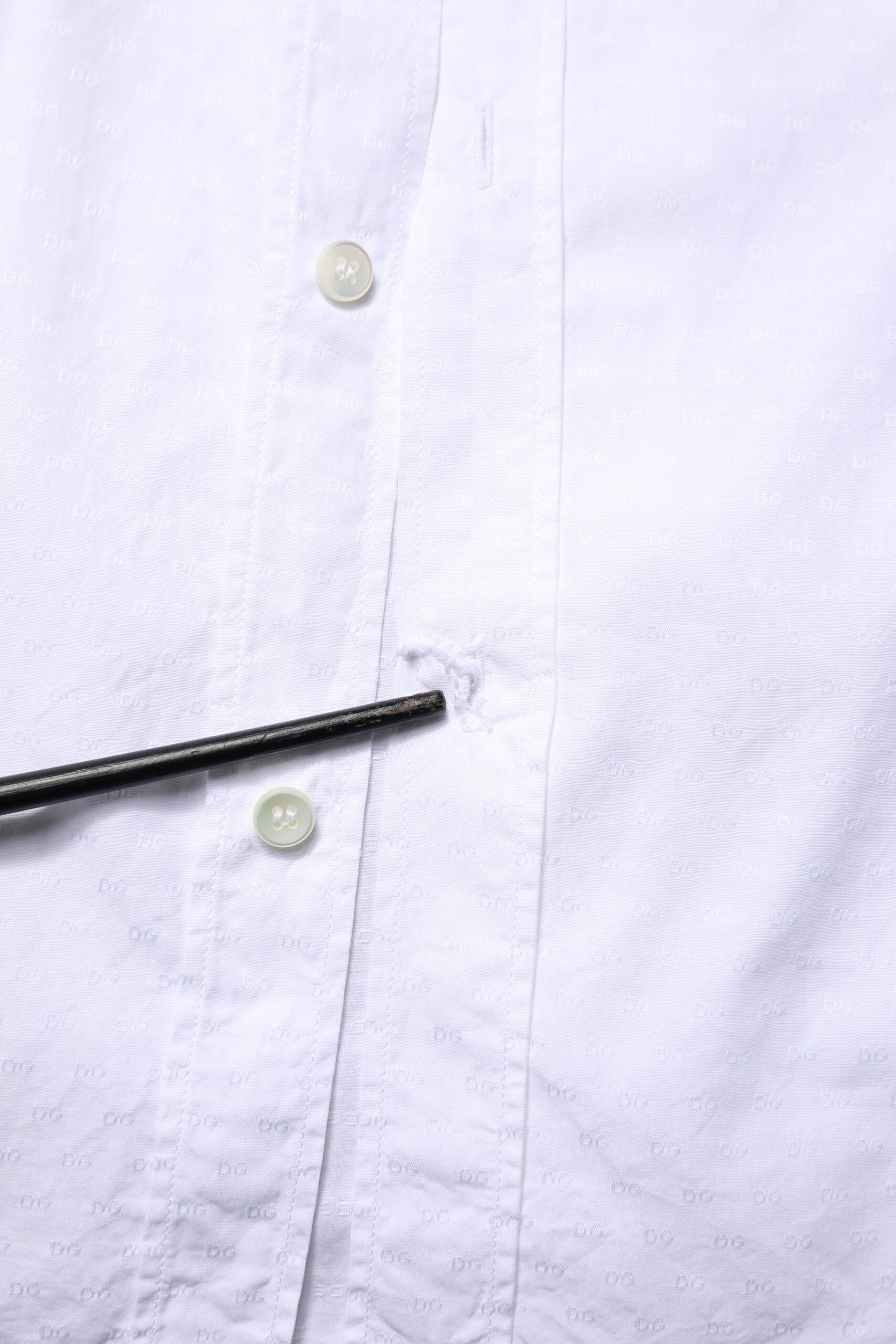 A white long sleeve dress shirt with gold buttons and a collar
