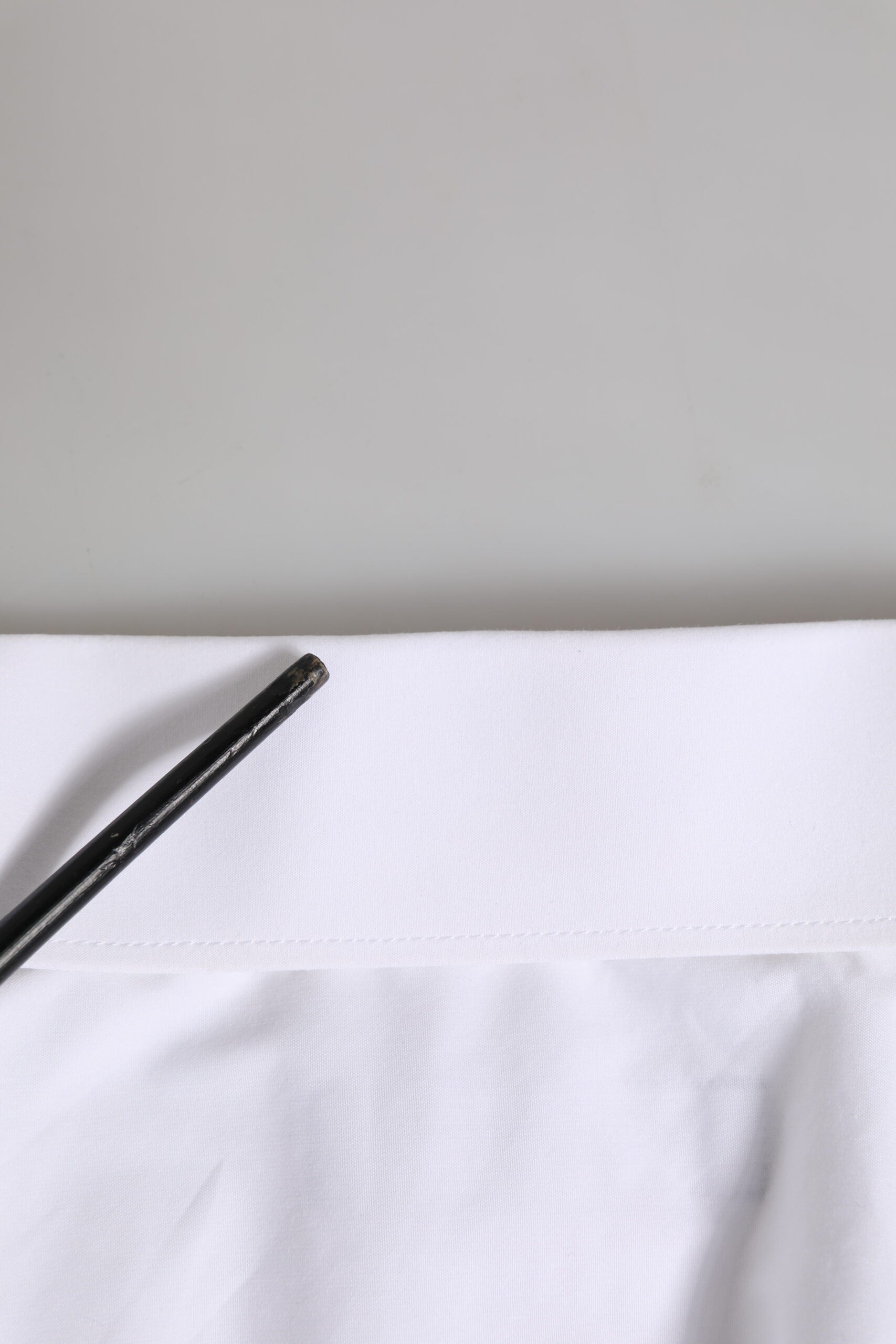 A white long sleeve dress shirt with gold accents, designed by Dolce & Gabbana