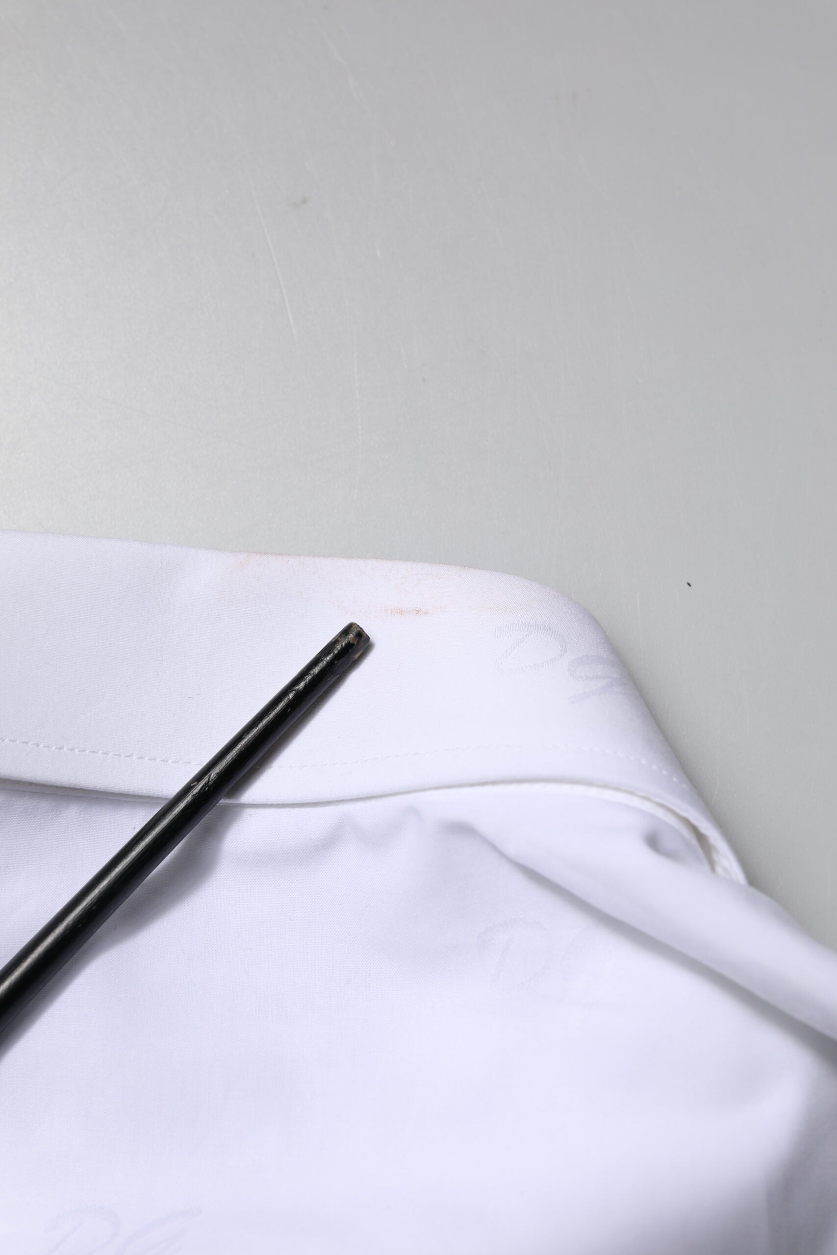 A white long sleeve dress shirt with gold accents, part of a formal wear collection by Dolce & Gabbana
