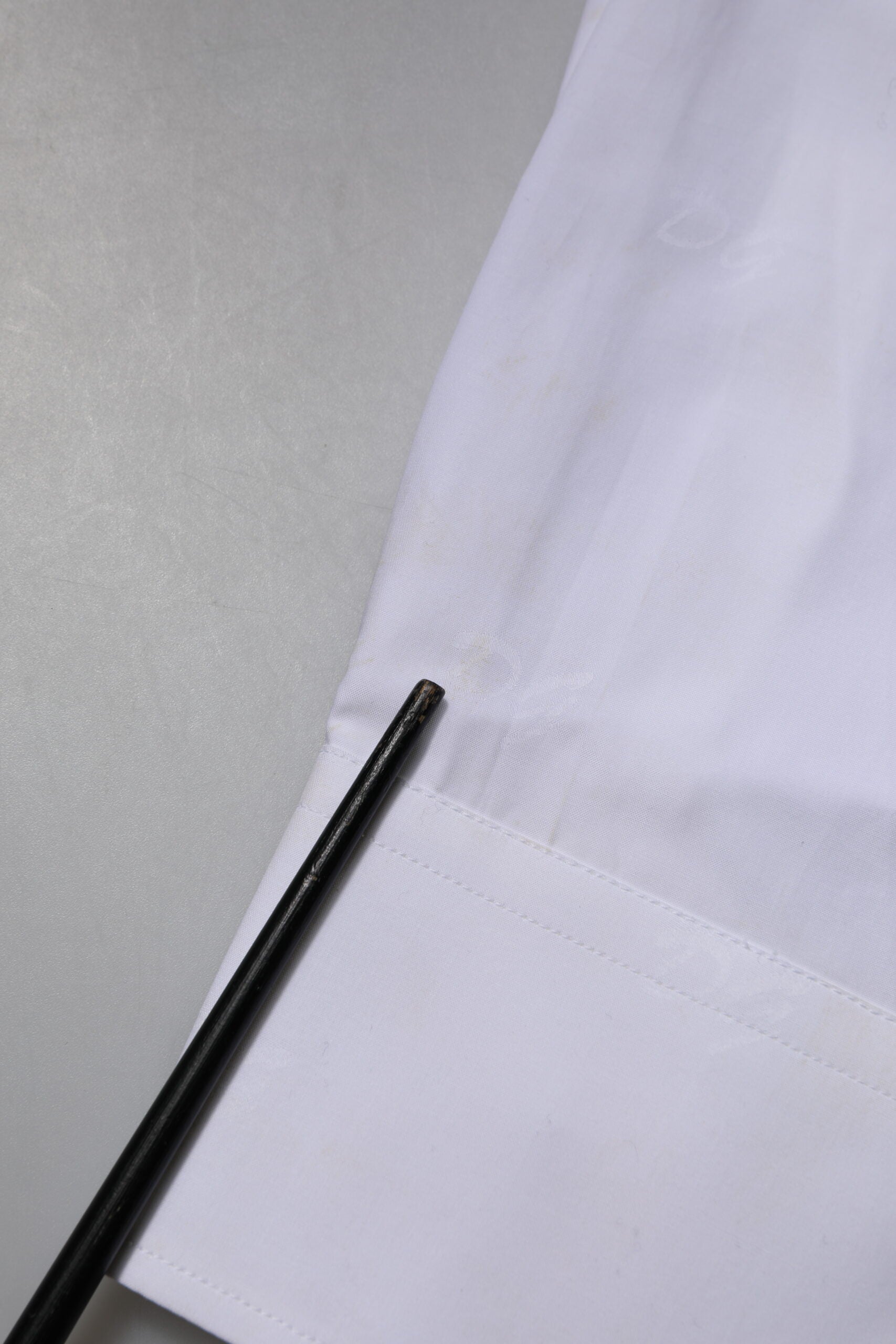 A black tie on a white shirt with gold trim