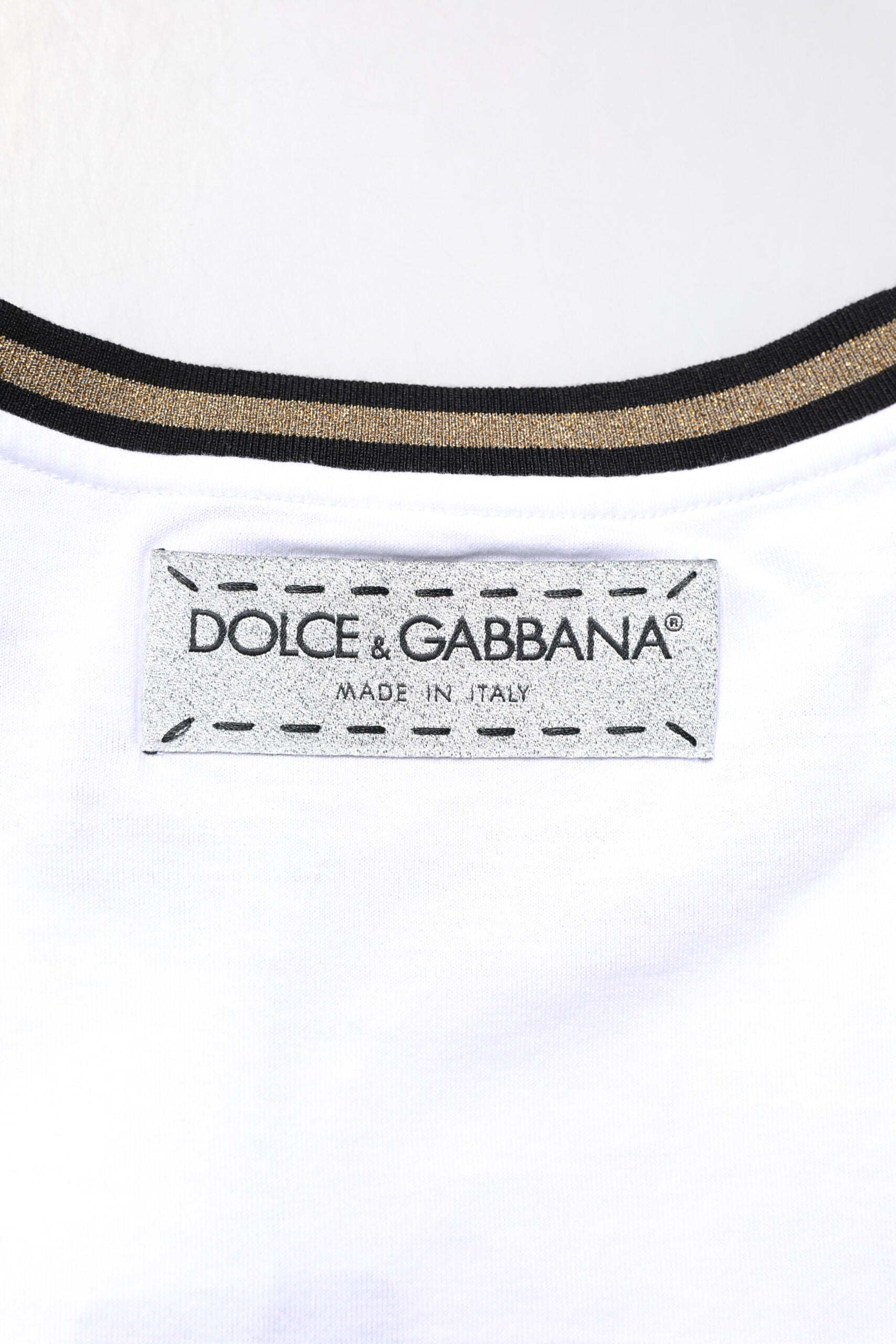 White shirt with black and gold stripe on collar