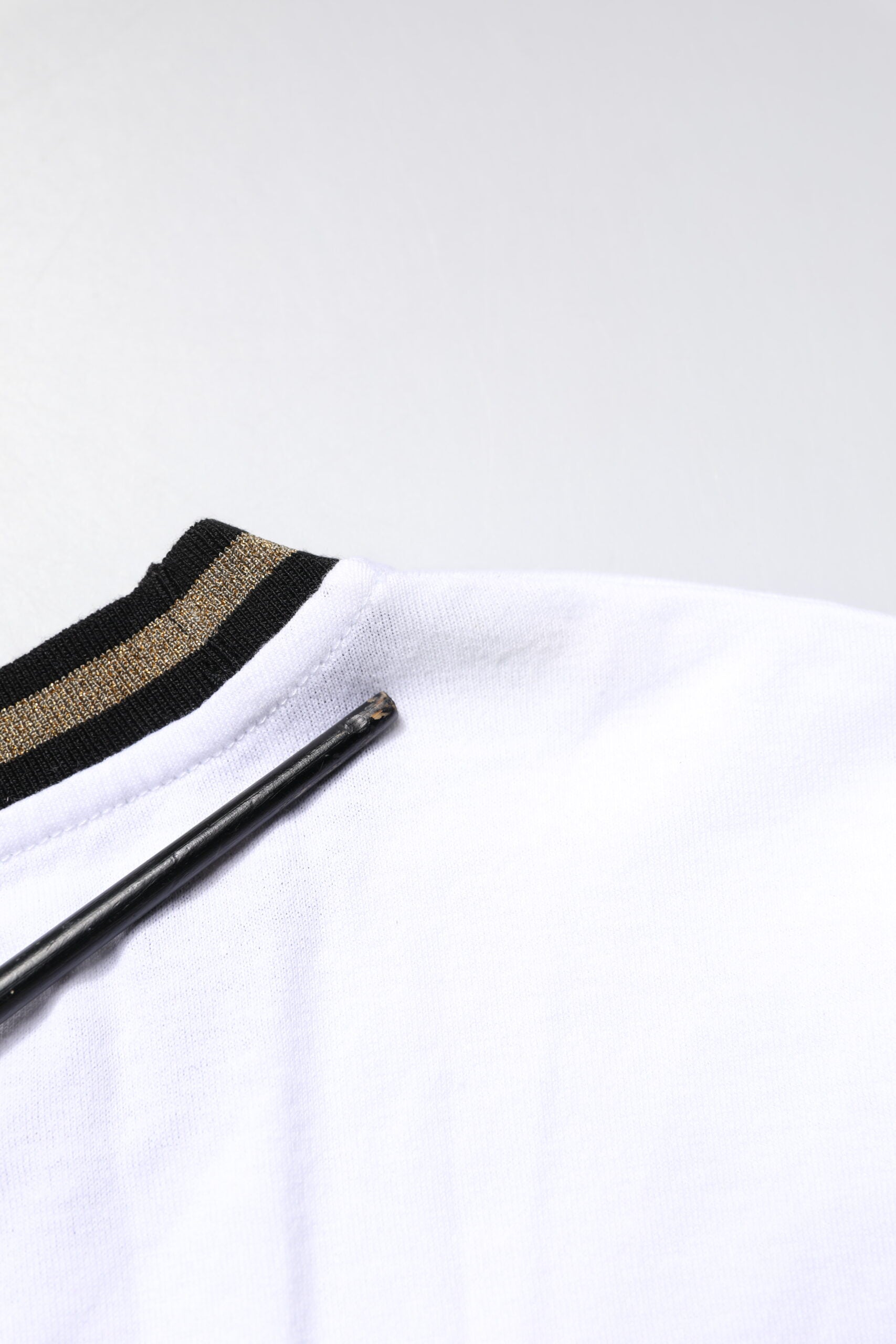 White jersey with gold stripes on sleeve