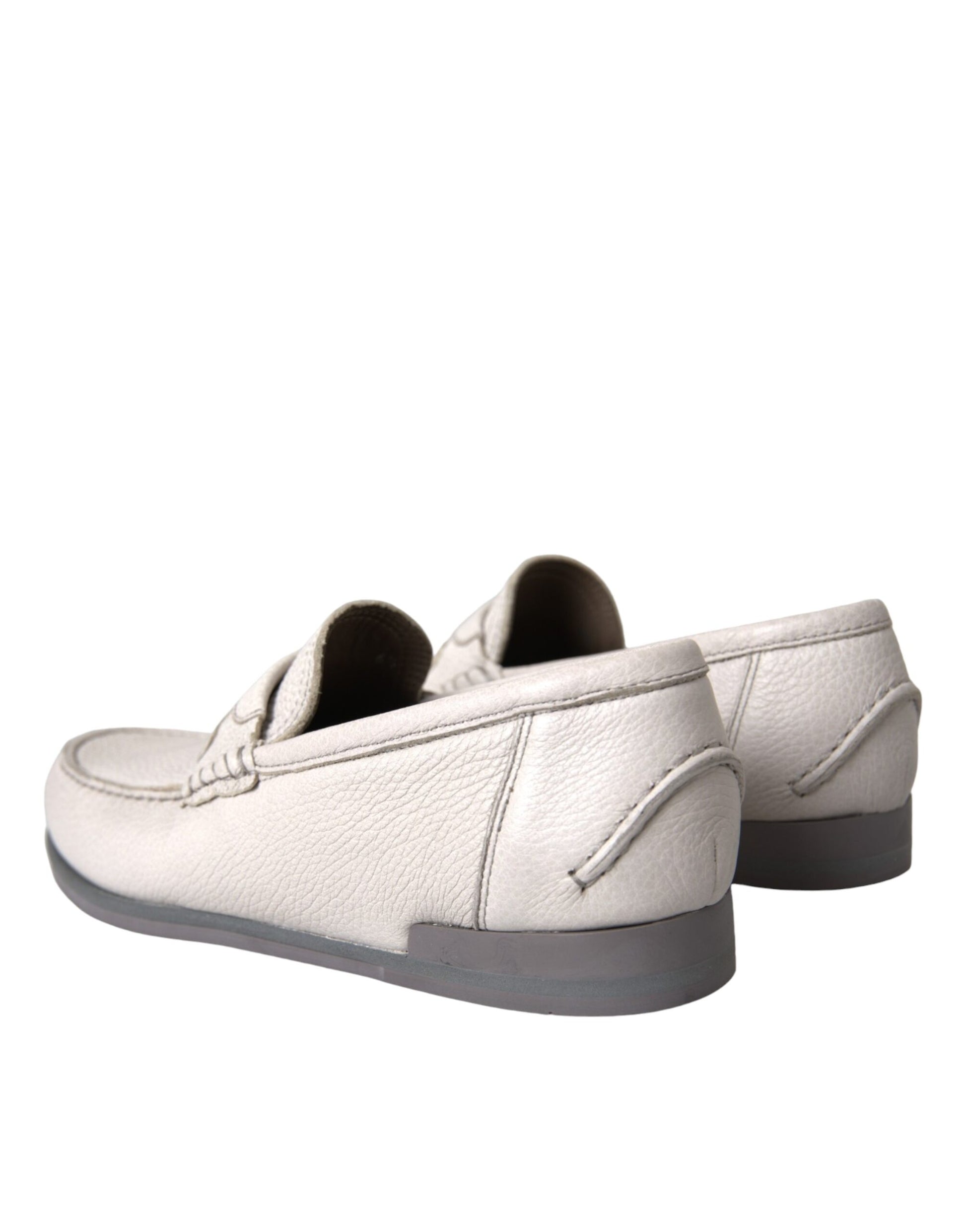 Pair of white slip on shoes with black soles