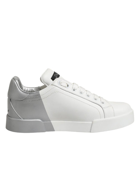 A pair of white and gray low top leather sneakers with a lace-up front