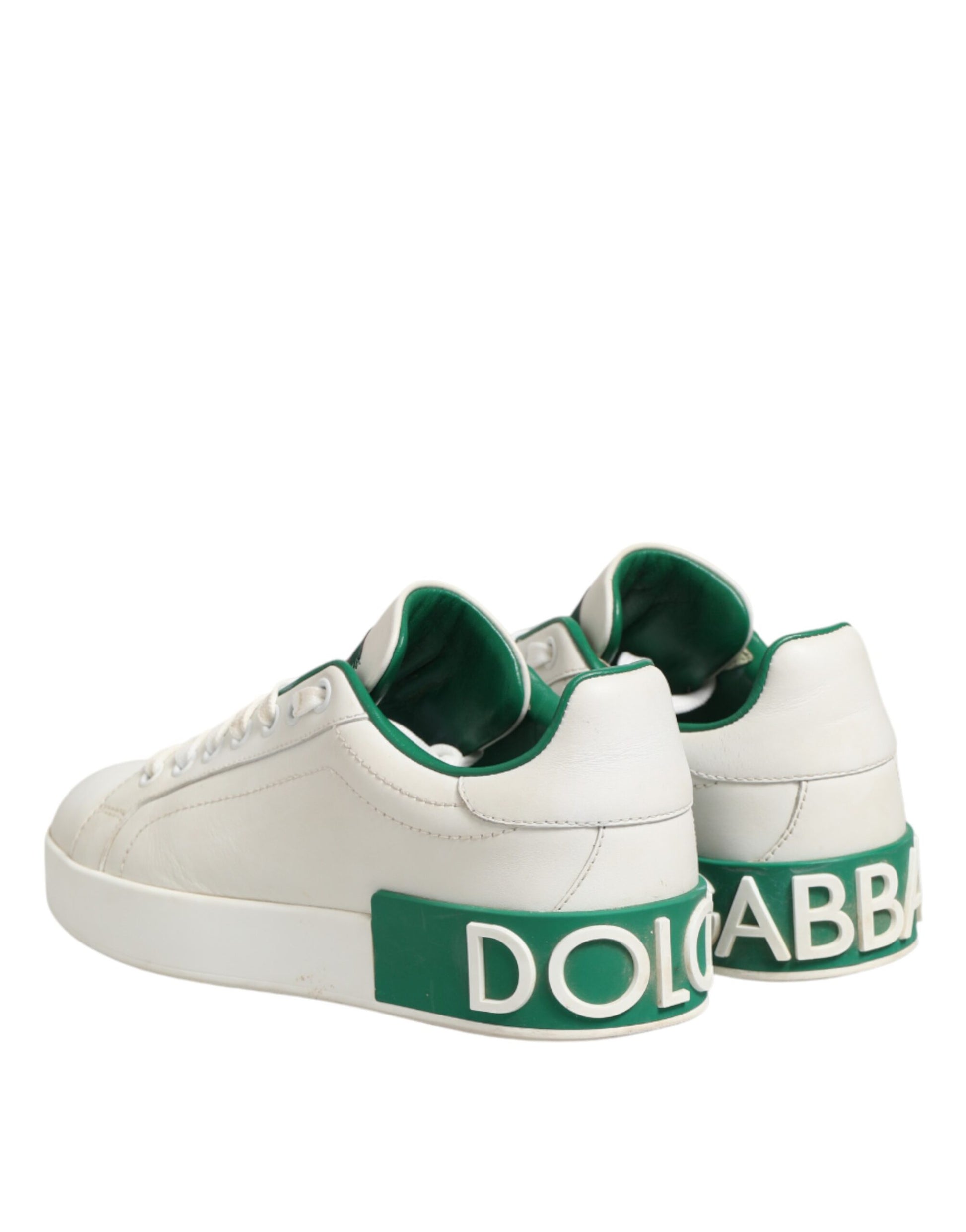 Pair of white sneakers with green accents and brand name on side
