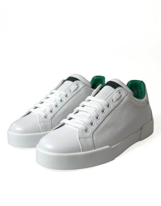 Pair of white sneakers with green accents and a black sole