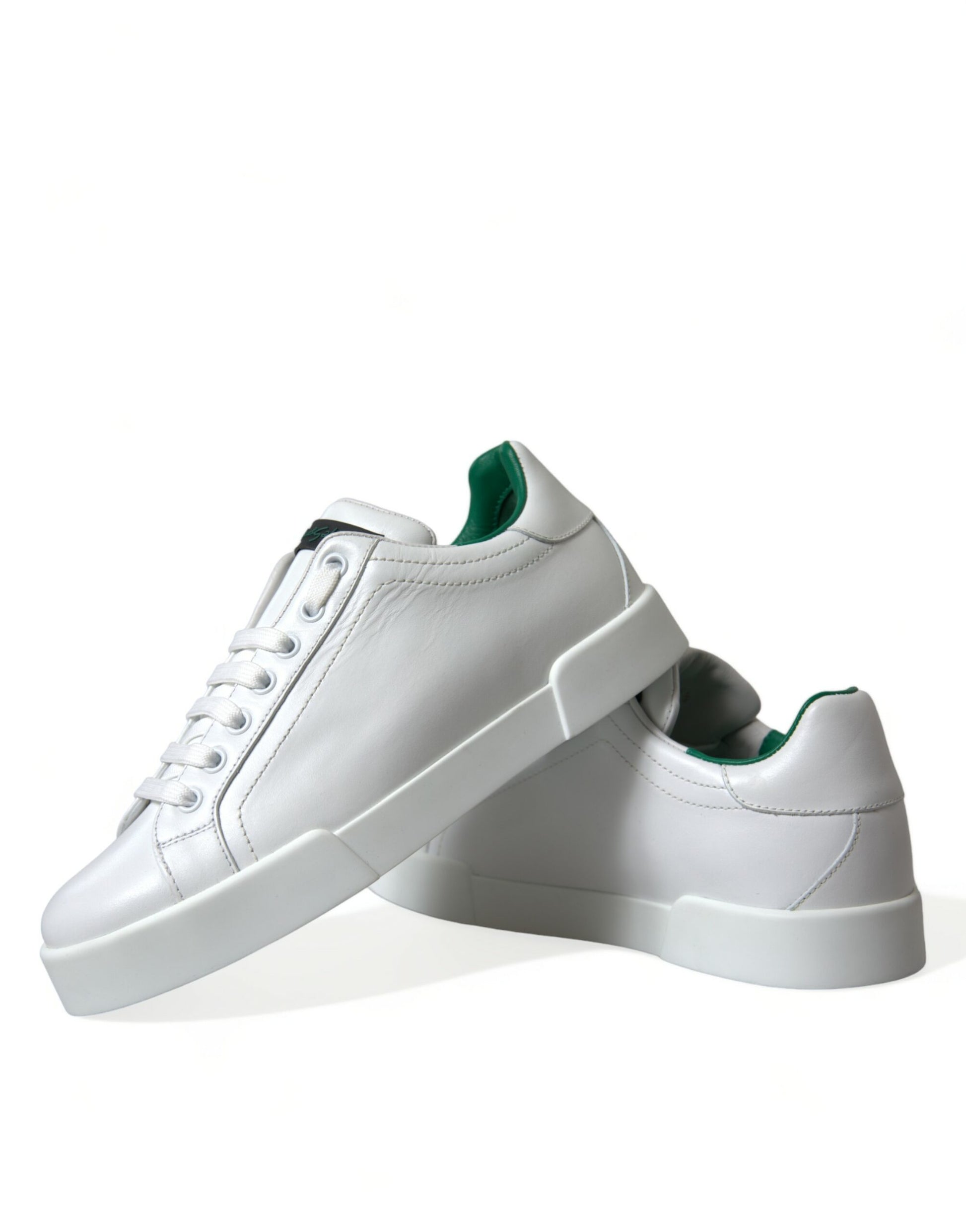 Pair of white sneakers with green laces and a black logo on the side