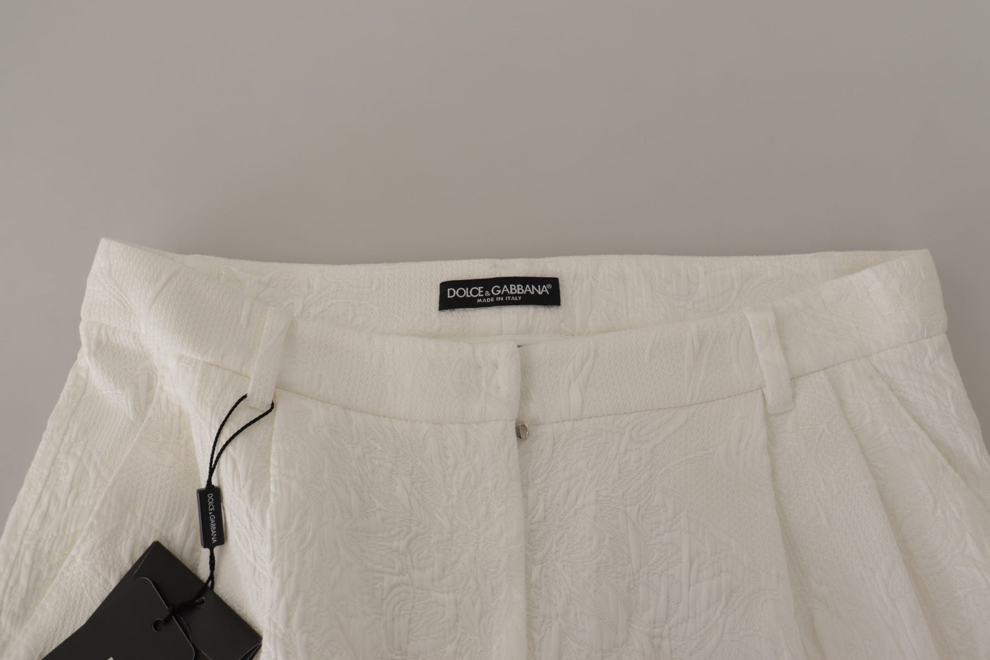 White fabric garment with black tag on hanger
