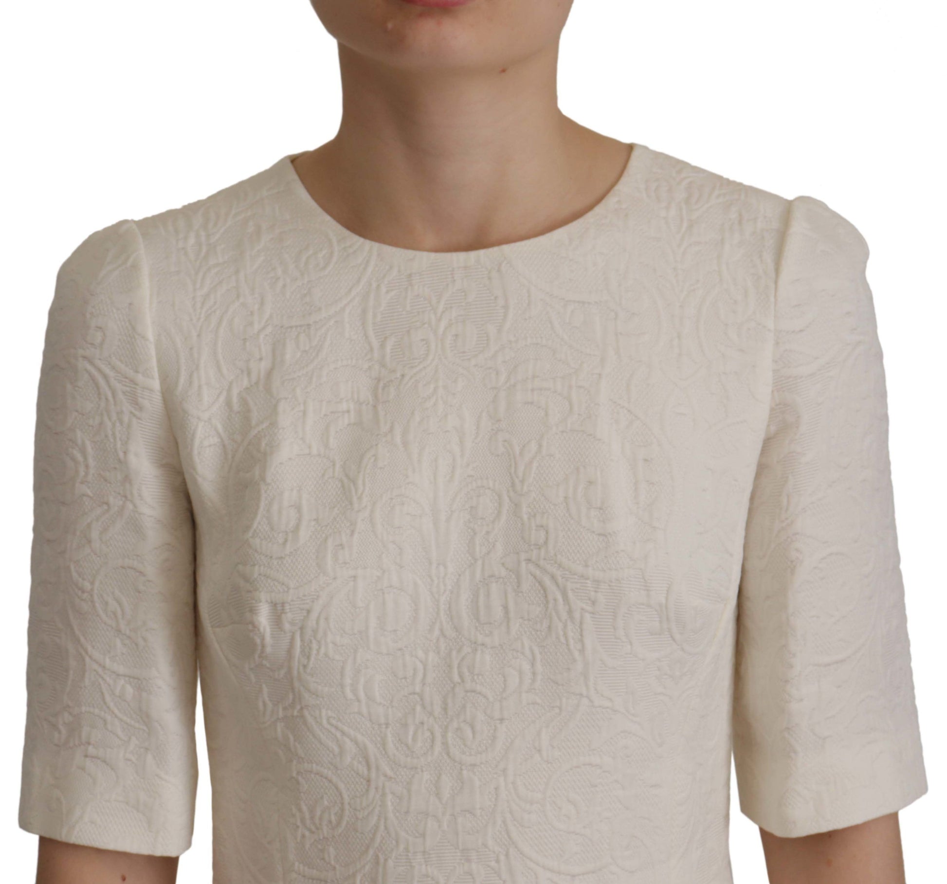 A white floral brocade midi dress with long sleeves and a fitted waist