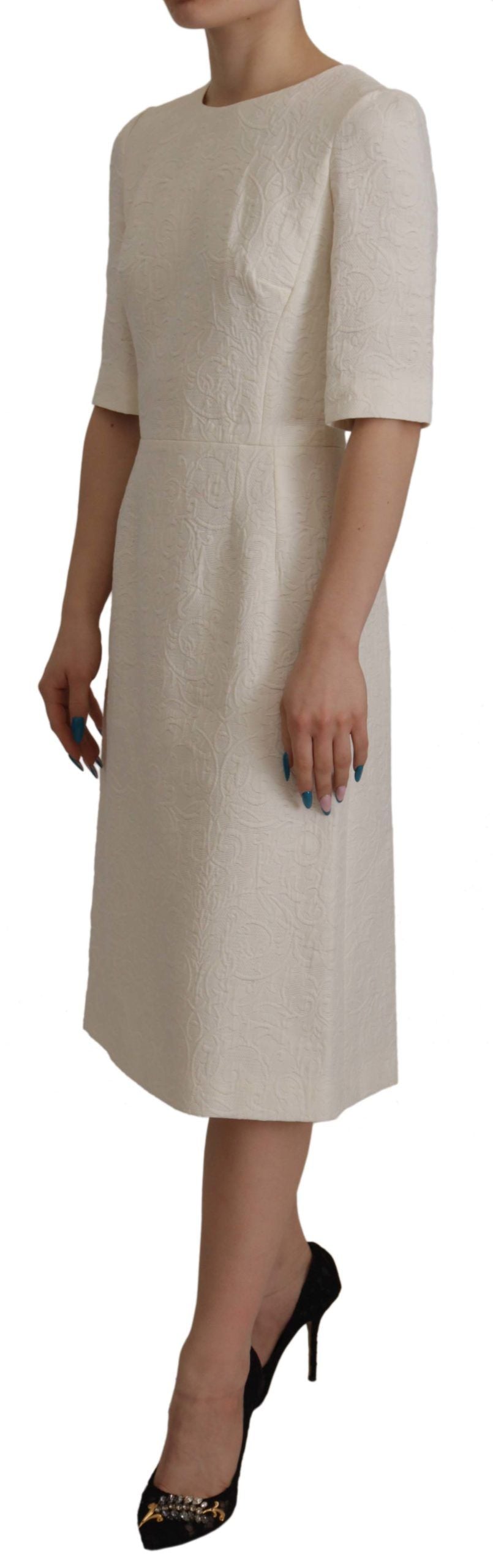 A white midi dress with floral brocade detailing and a sheath silhouette