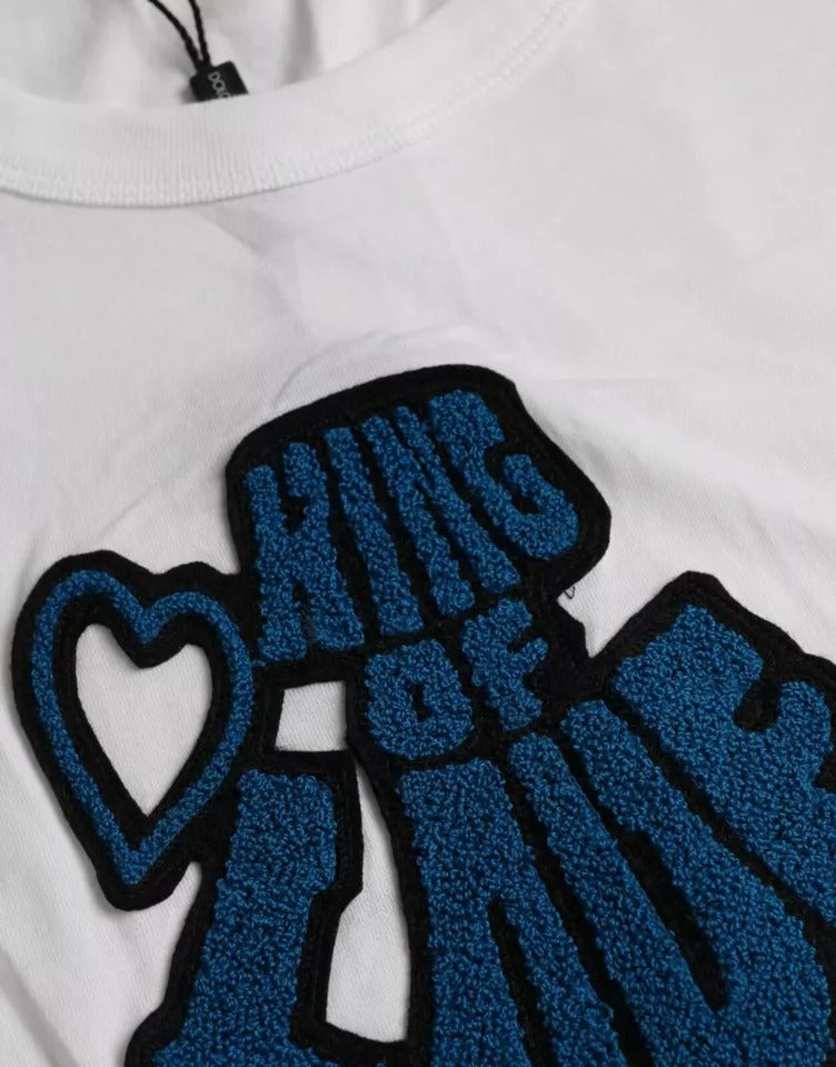 White t-shirt with blue embroidery featuring a heart and text reading "King of Love