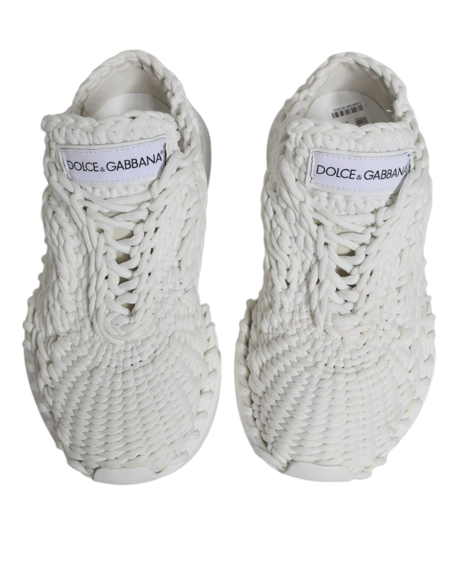 Pair of white knitted sneakers with black text on tongue and heel, featuring a unique knit pattern