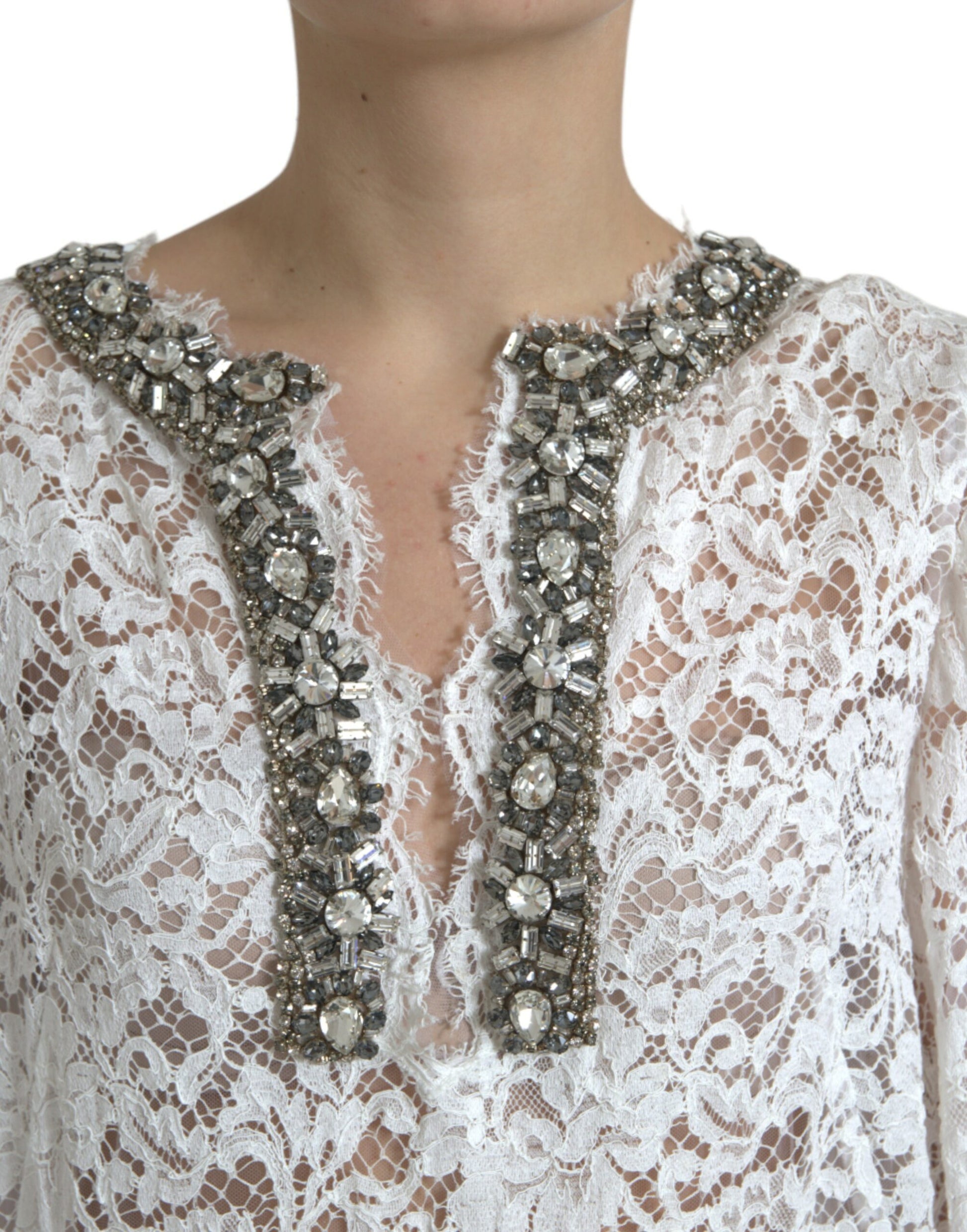 A white lace dress with crystal embellishments on the neckline and sleeves