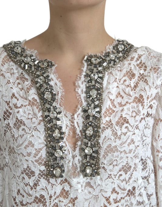 A white lace dress with crystal embellishments on the neckline and sleeves