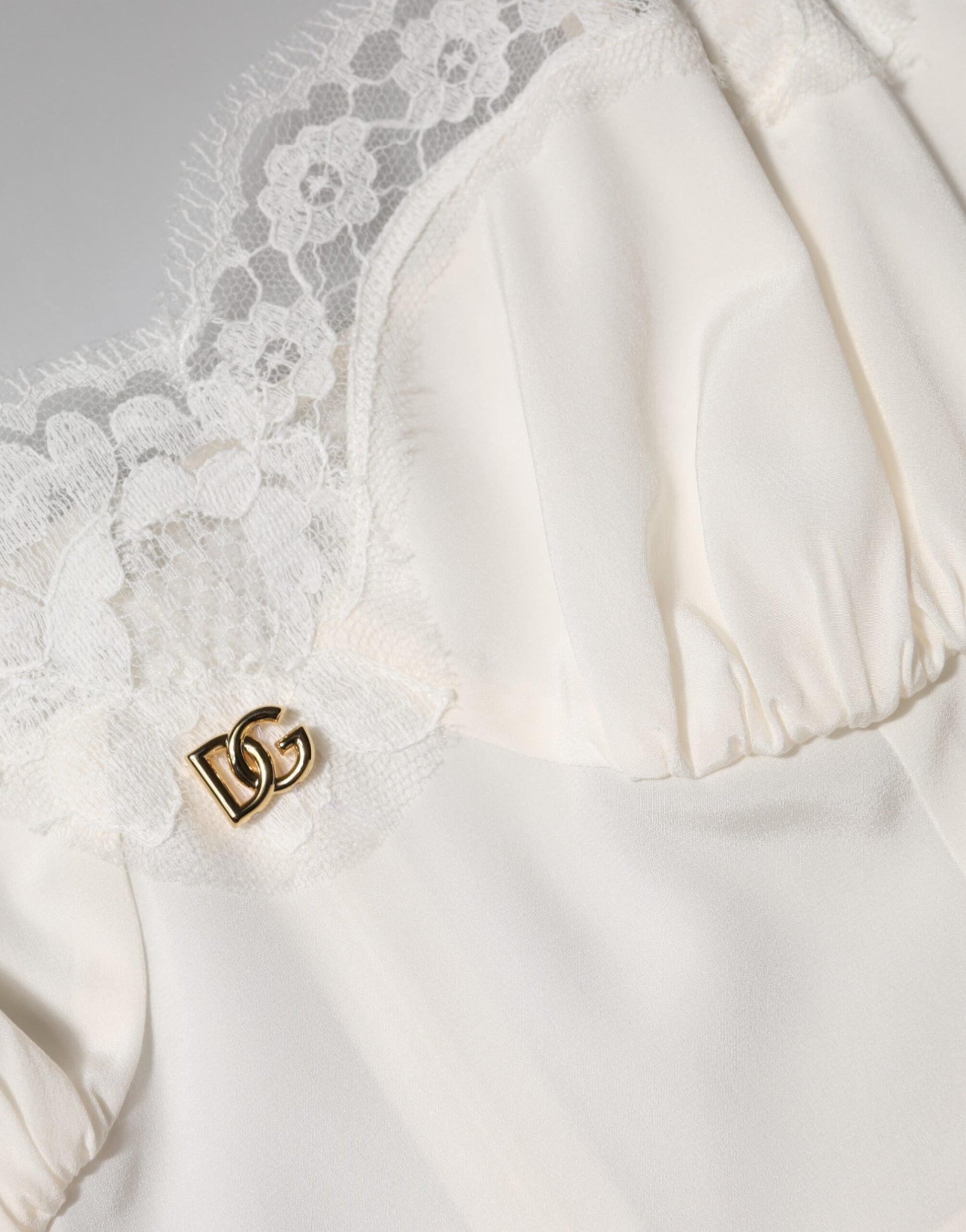 A white lace dress with a D&G logo on the chest