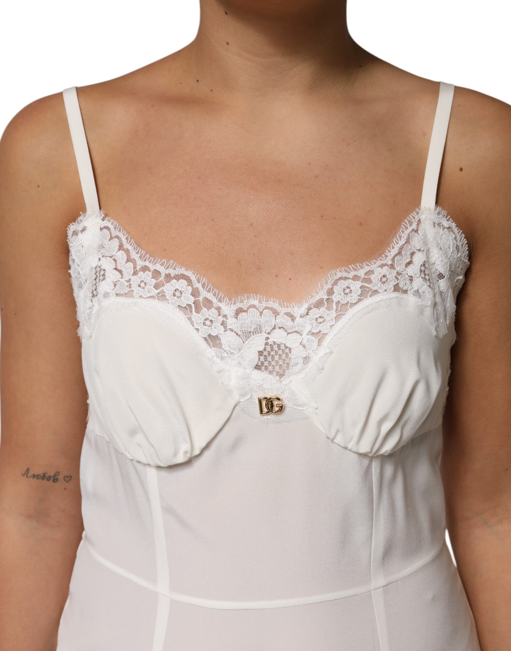A white lace dress with a gold D&G logo, featuring a silky texture and sleepwear design