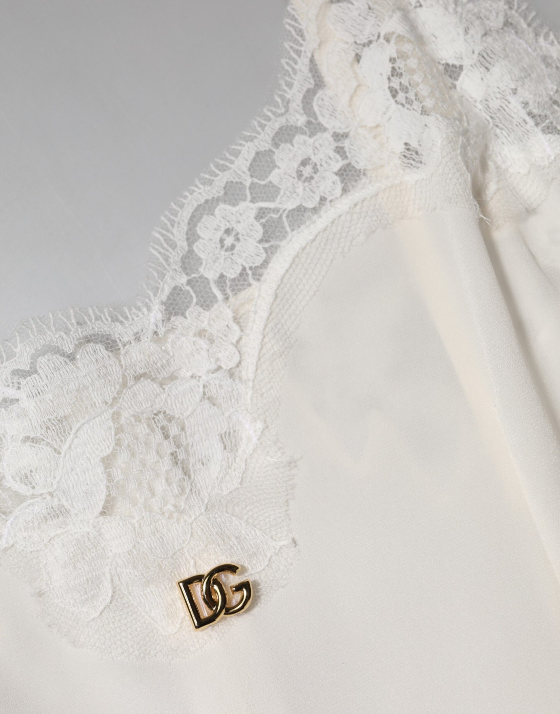 A white lace dress with a gold D&G logo on the chest