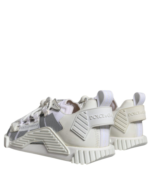 A pair of white lace-up sneakers with a low top, featuring the brand name "Dolce & Gabbana" and the model "NS1"