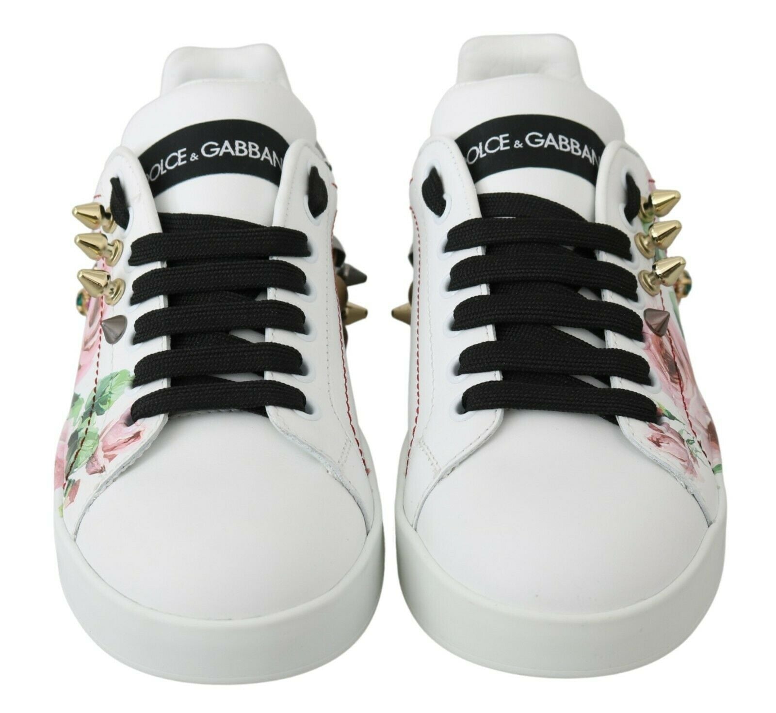 Pair of white sneakers with black laces and floral pattern on side