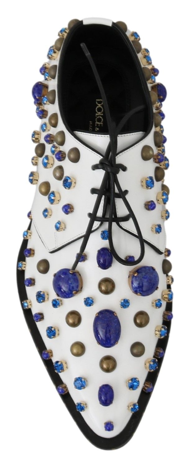 Decorative shoe with blue and gold stones on a black background