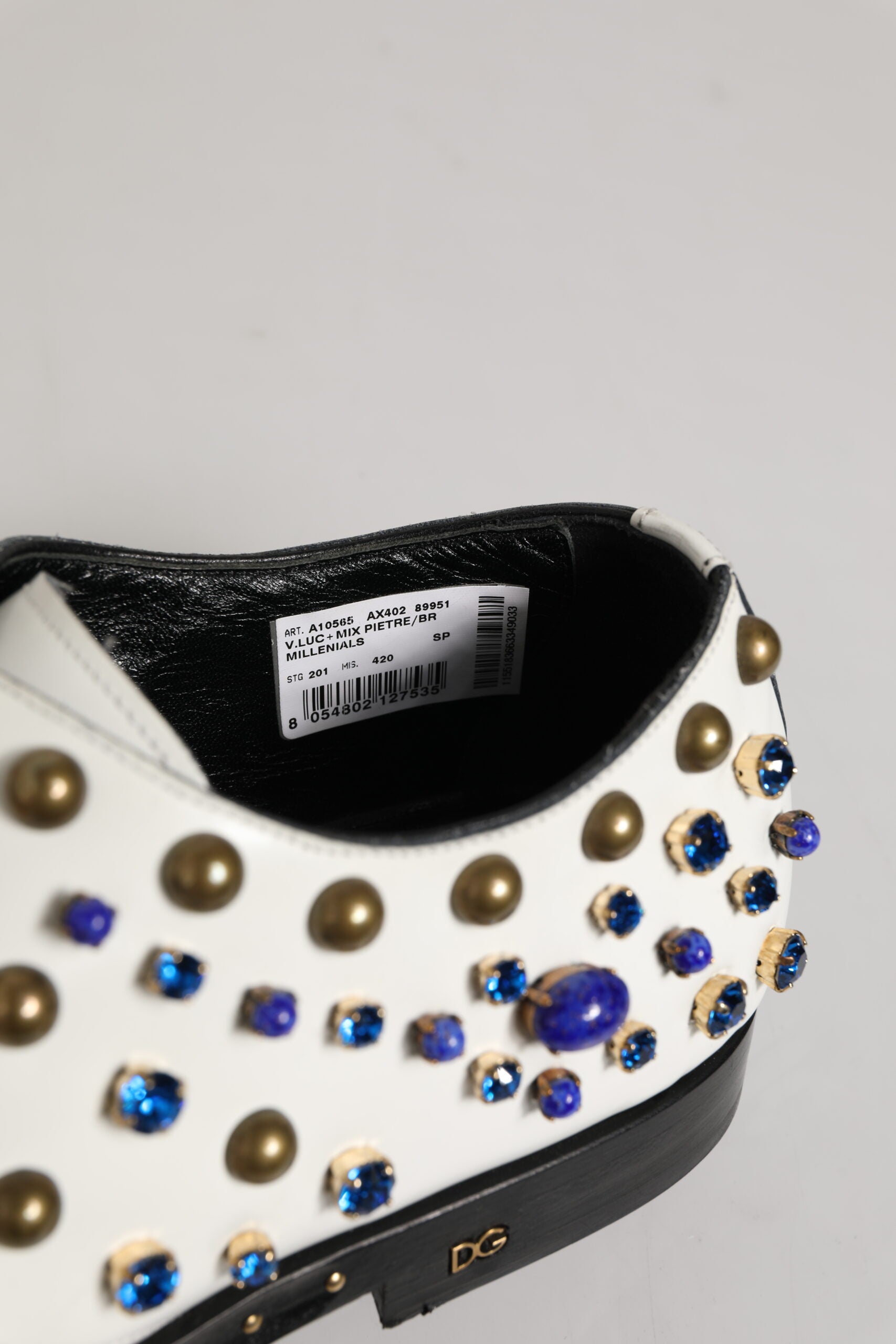 A pair of white leather shoes with crystal embellishments on the toe and heel