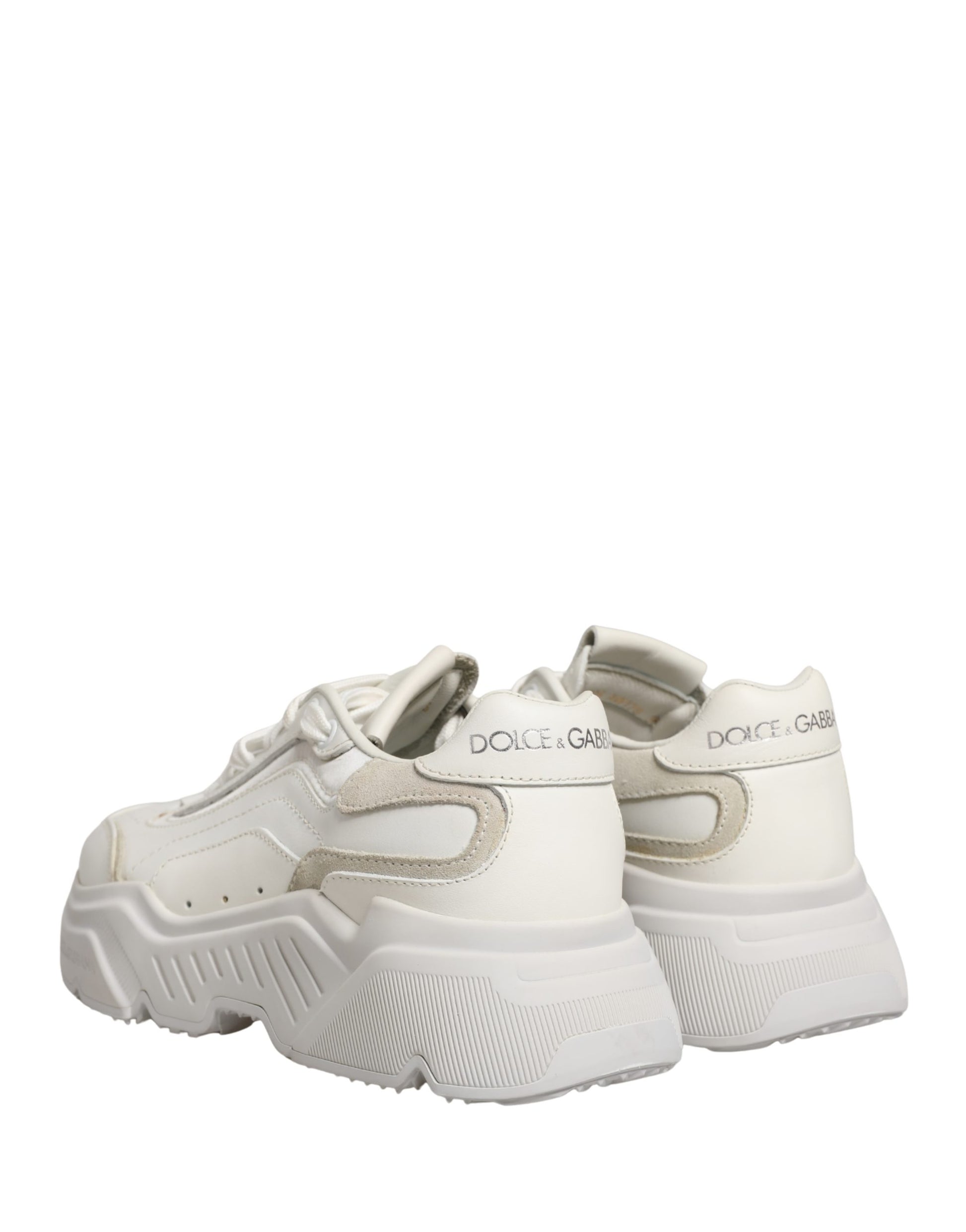 Pair of white leather sneakers with low top, featuring brand name on side and laces