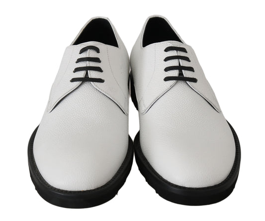 Pair of white leather shoes with black laces and soles