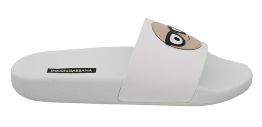 Pair of white flip flops with a cartoon character on the strap