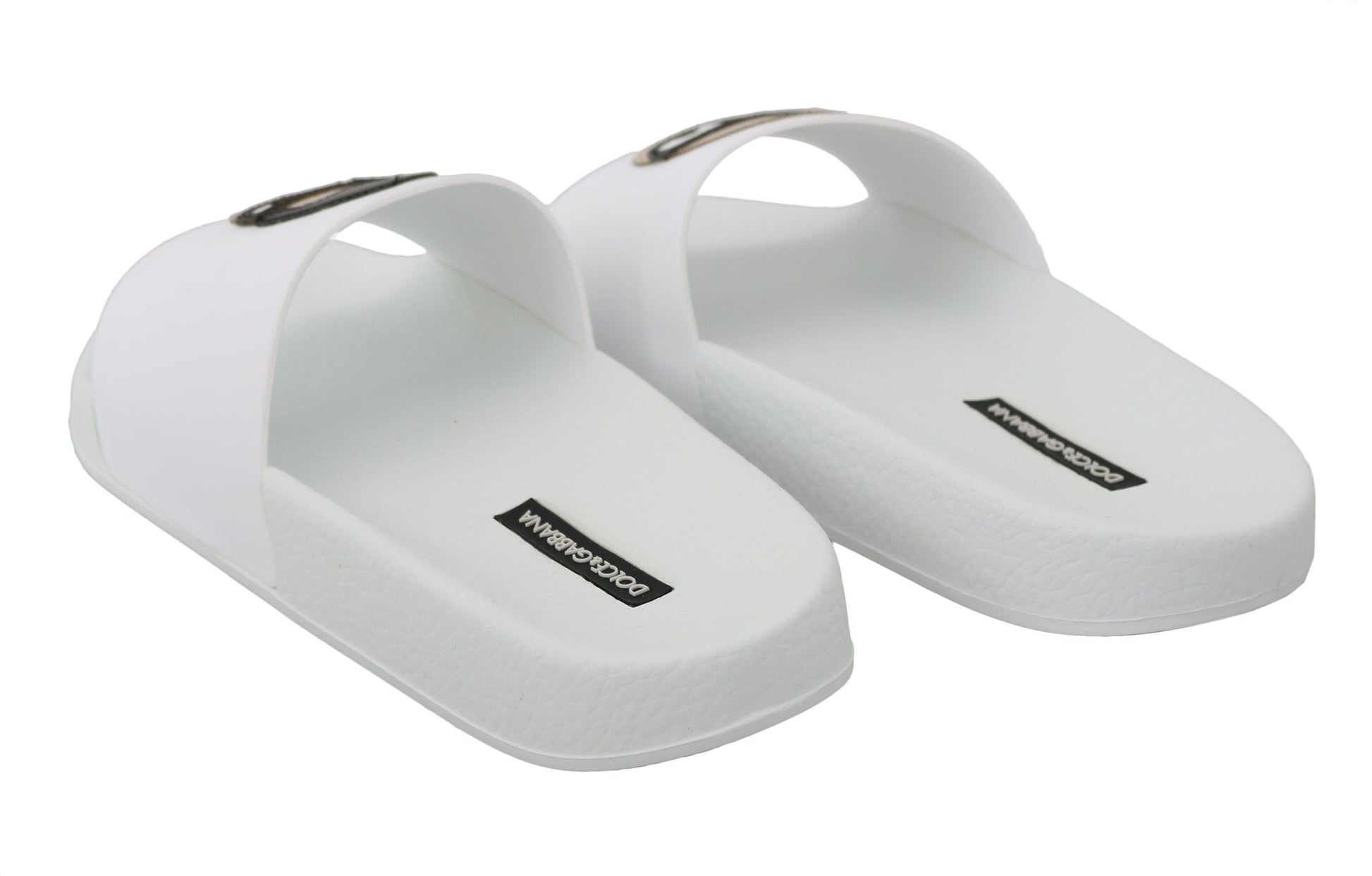 Pair of white flip flops with black logo on soles