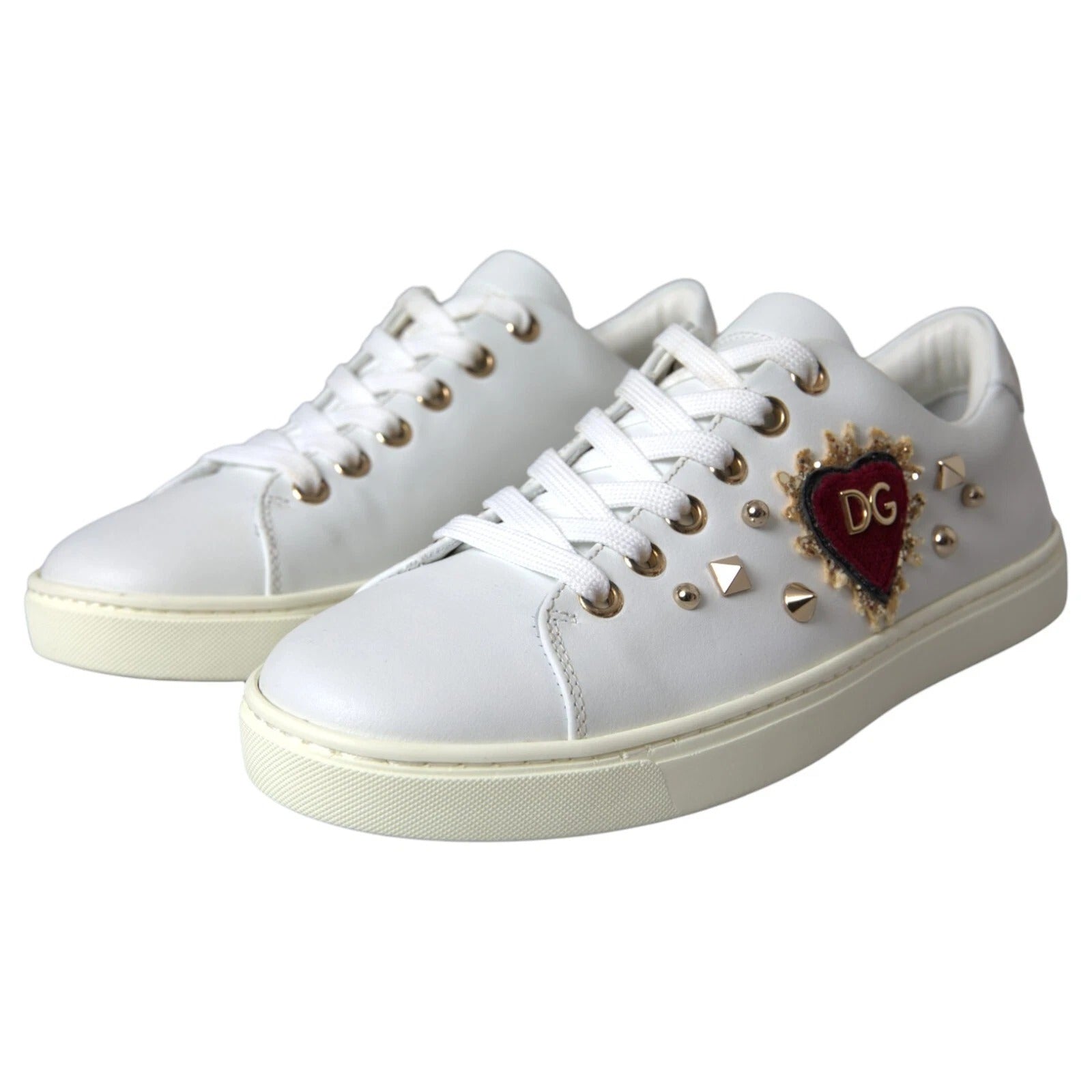 White sneakers with gold studs and a heart logo on the side