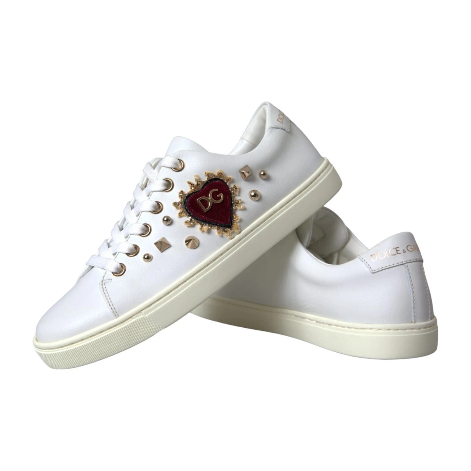 White sneakers with gold accents and a heart design on the side