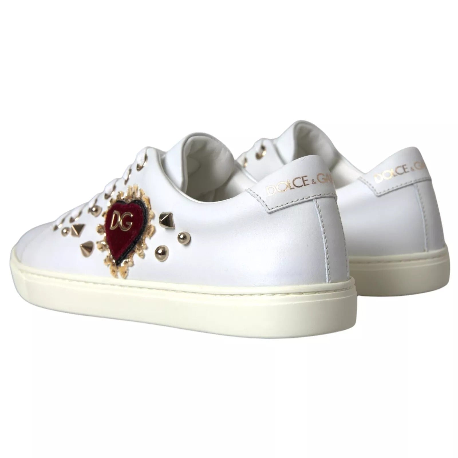 White sneakers with gold accents and a heart design on the side