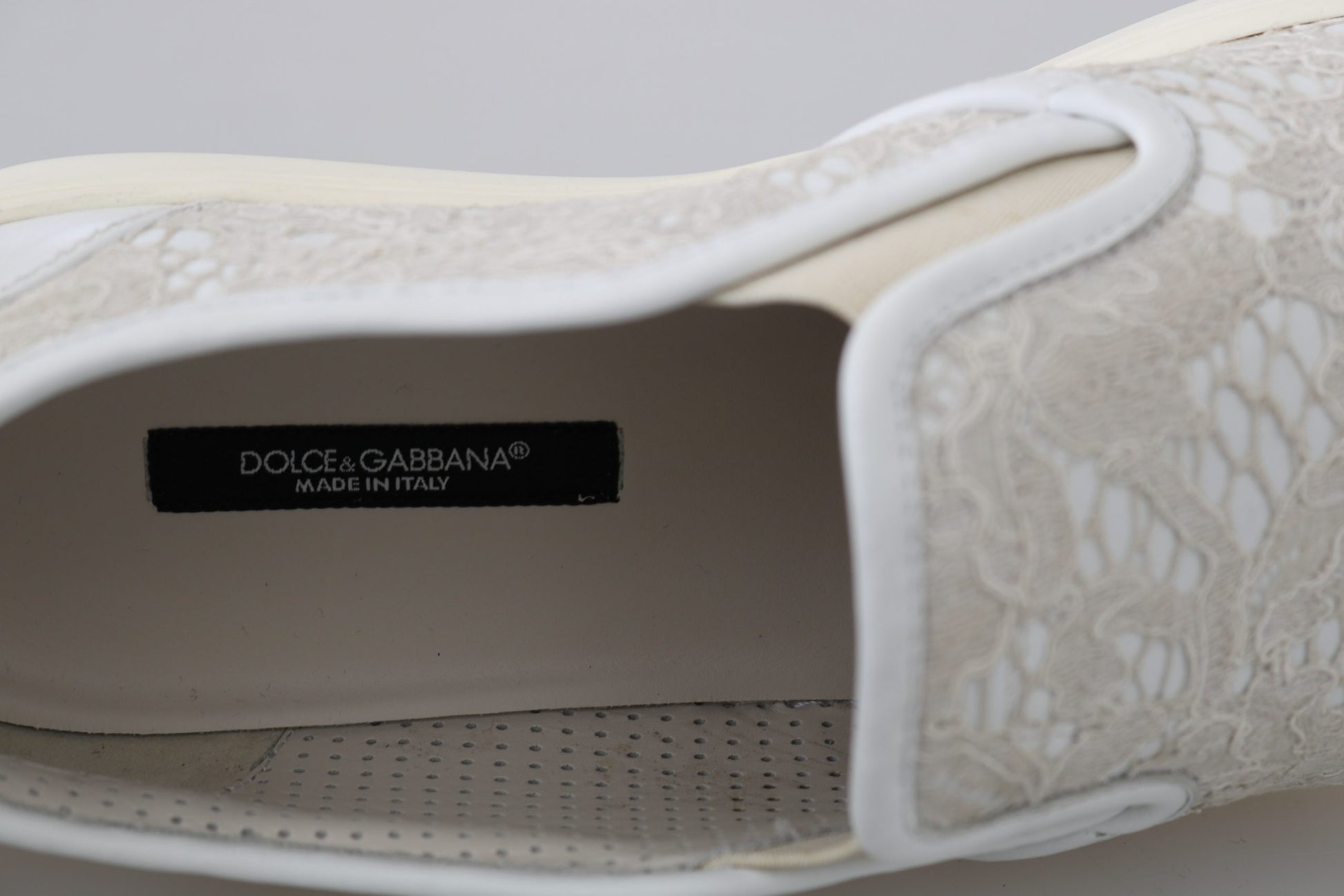 A single shoe with an open toe box. Inside the toe box is a label that reads DOLCE & GABBANA. The shoe appears to be a wo