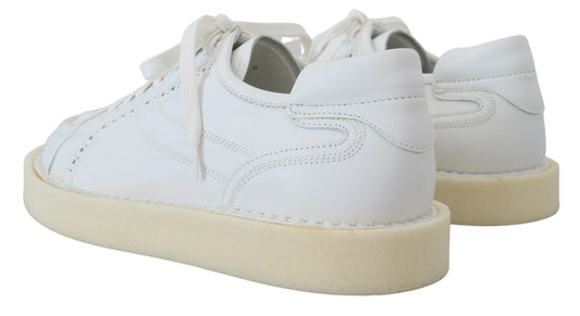 Pair of white sneakers with tan soles and laces