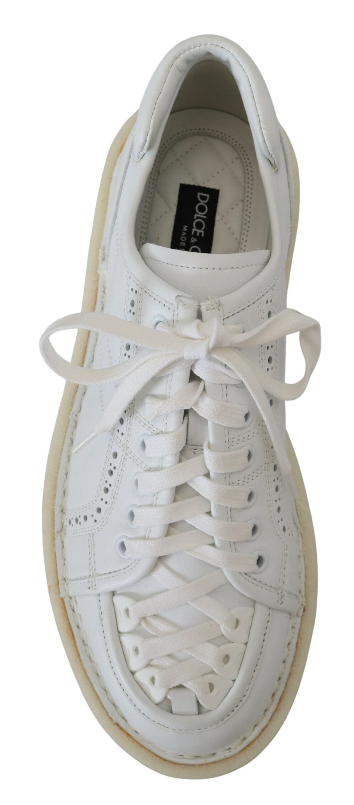 White sneaker with laces and a small black logo on the tongue