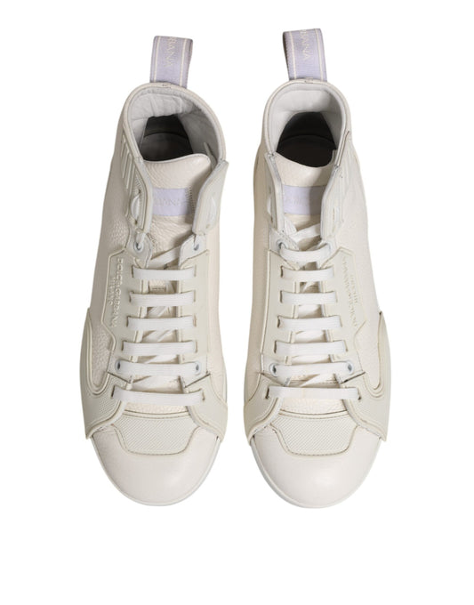 Pair of white leather mid top sneakers with laces and a logo on the side
